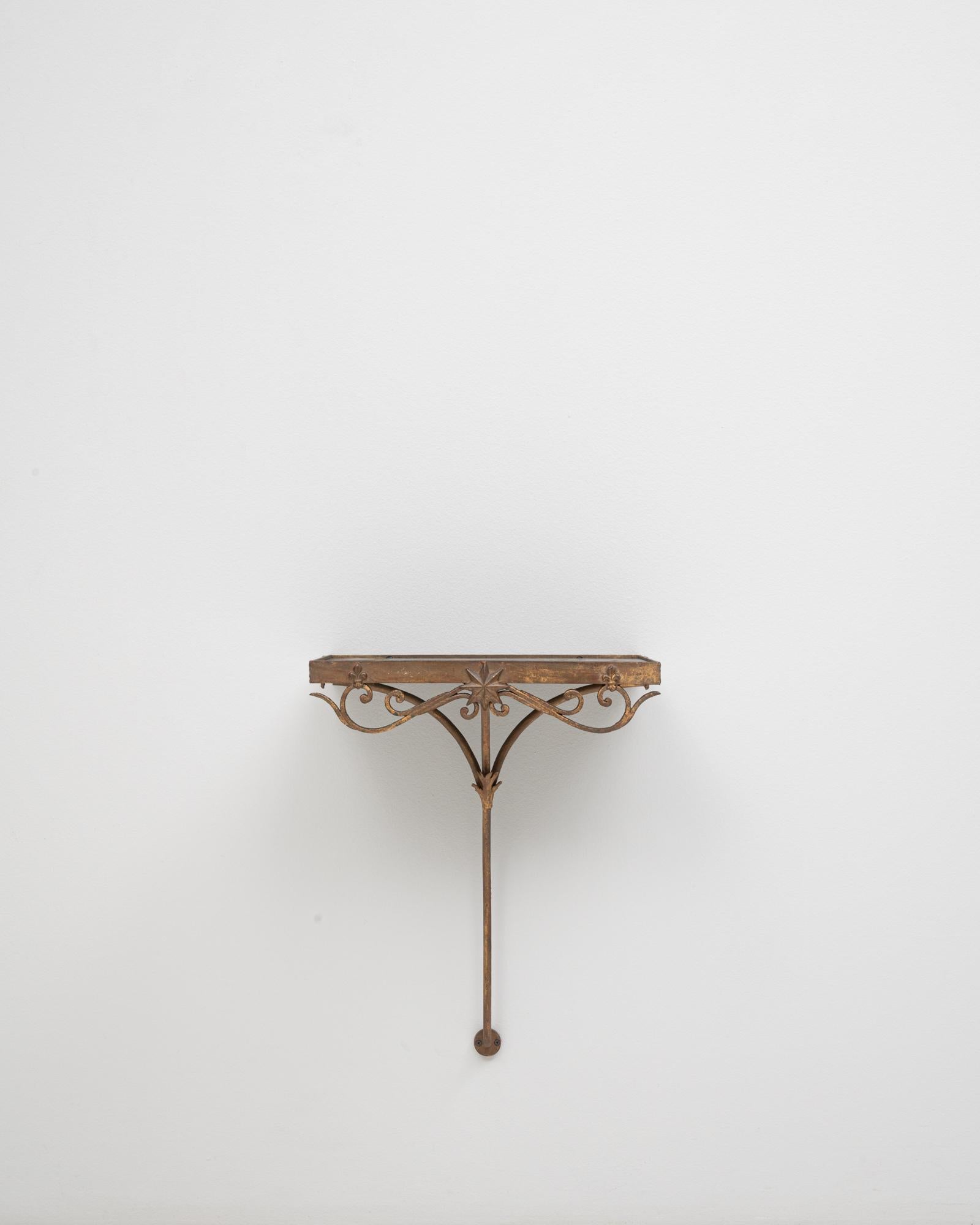 Cette console française en métal des années 1910 avec plateau en marbre présente le mélange parfait de force et de raffinement caractéristique du design français du début du XXe siècle. La base en métal forgé à la main présente des détails