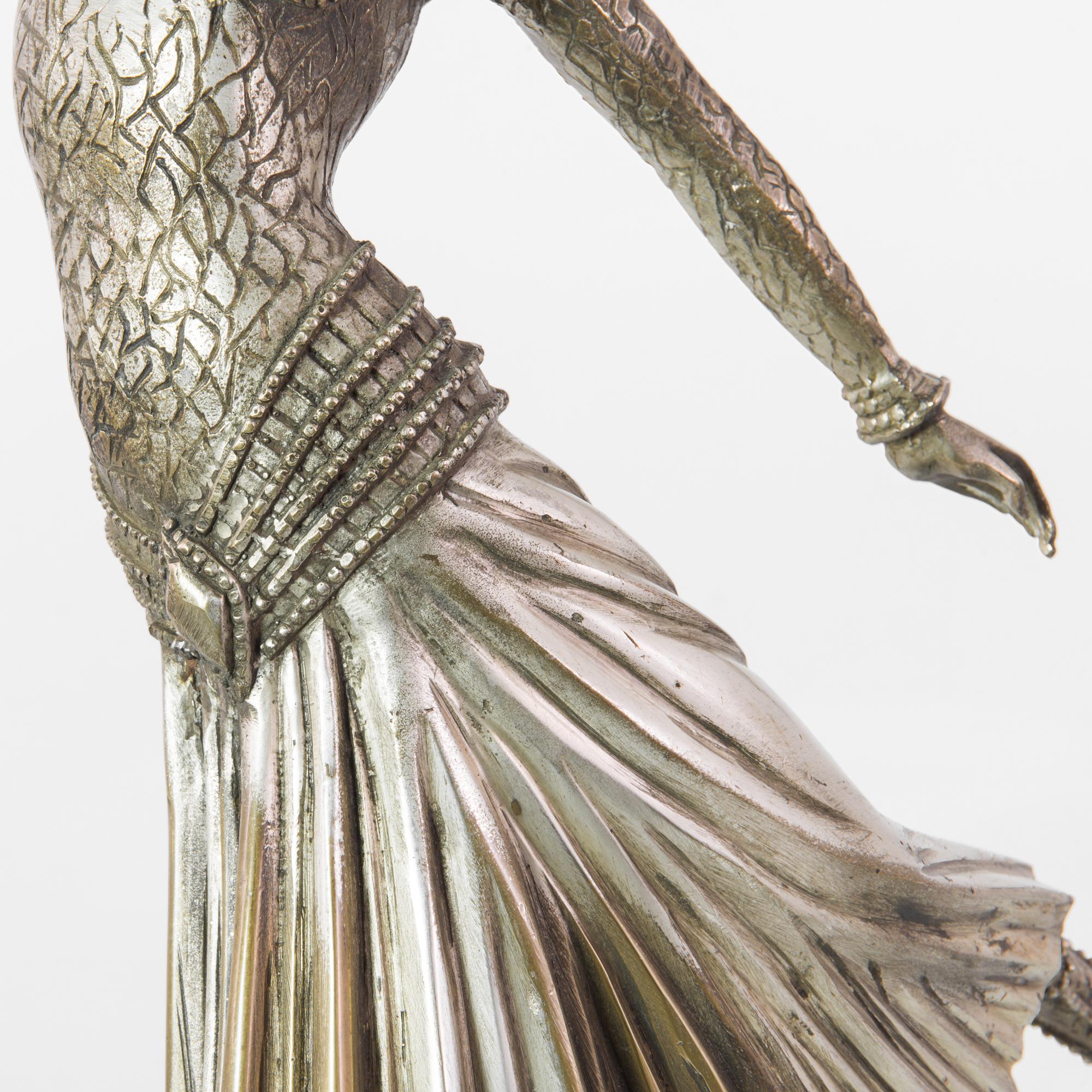 Step into the enchanting world of the early 20th century with this 1910s French Silver-Plated Woman Sculpture. This captivating bronze masterpiece breathes life into the art of dance, capturing the essence of grace, agility, and flexibility embodied
