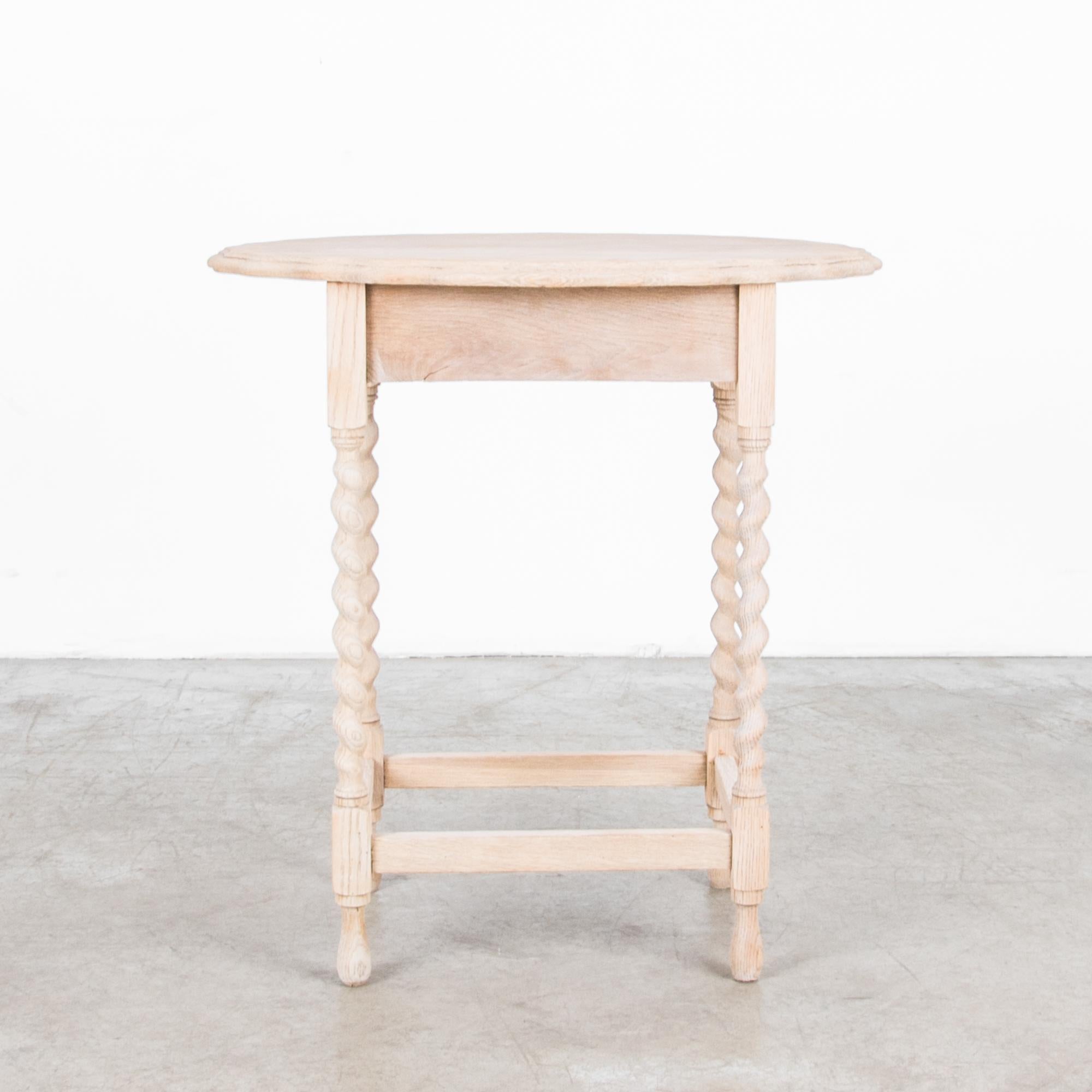 A wooden table with spiral turned legs from France, circa 1910. Made of oak, the round, scalloped tabletop and the graceful spiral of the legs provide a slender elegance, while a square apron and gated legs lend a Provincial accent. The light tone