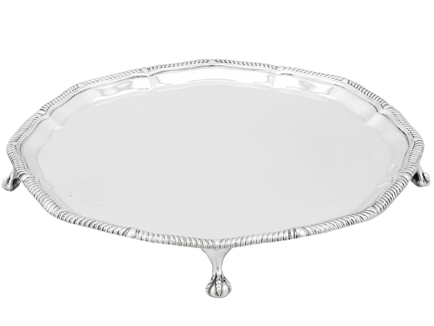 A fine and impressive antique George V English sterling silver waiter made in the George III style; an addition to our dining silverware collection.

This fine antique George V sterling silver waiter has a circular incurved, shaped form.

The