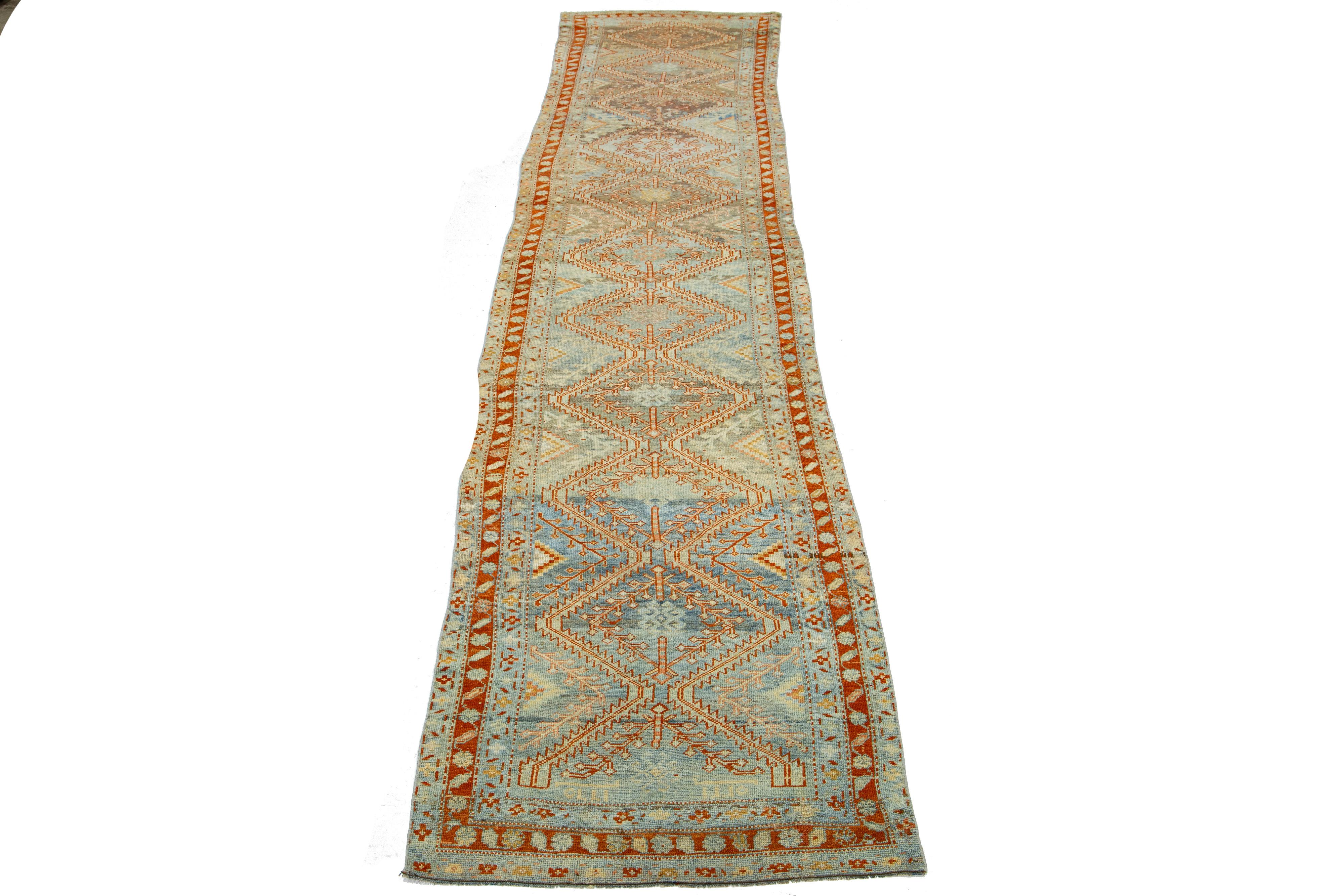 Beautiful antique Malayer Persian runner rug with a light blue field. This piece has rust accents with an all-over tribal floral design. 

This rug measures 3'4