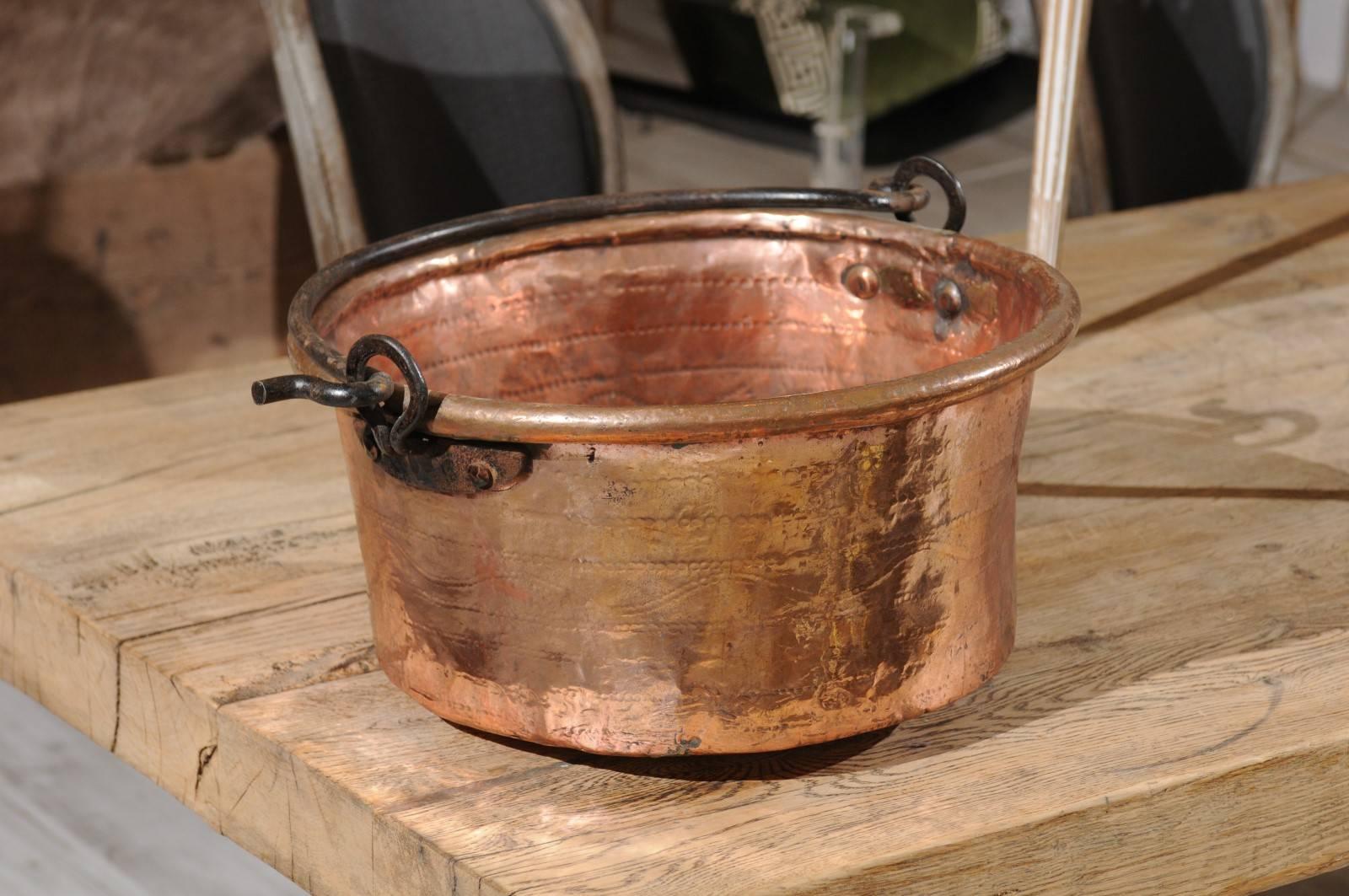 French early 20th century circular copper pot with movable iron handle. 