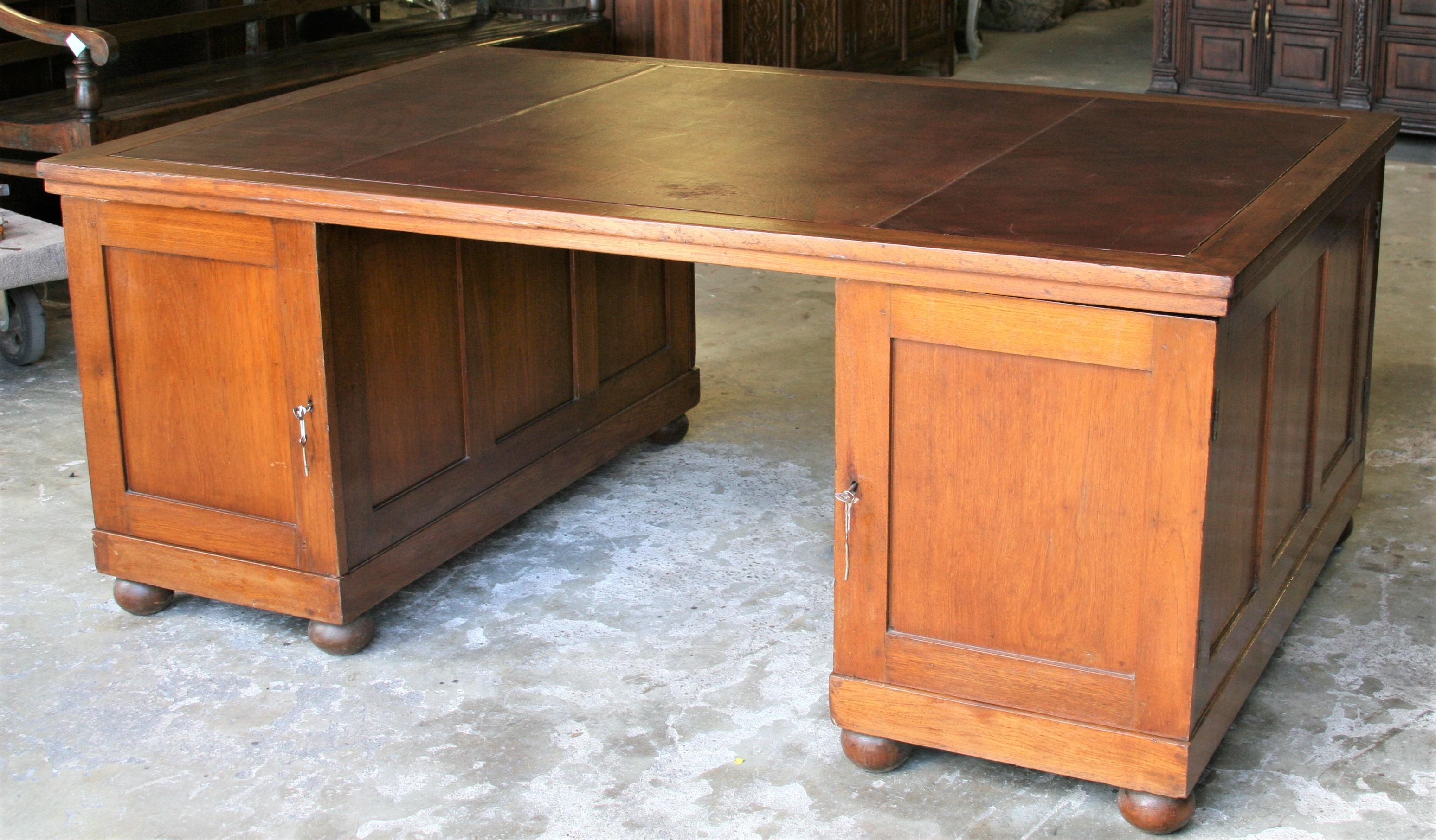 This piece of furniture was first conceived in the United Kingdom to accommodate the work of banking partners. This is a beautifully conceived and made desk for a senior personnel in the bank. The desk consists of three parts the top and two