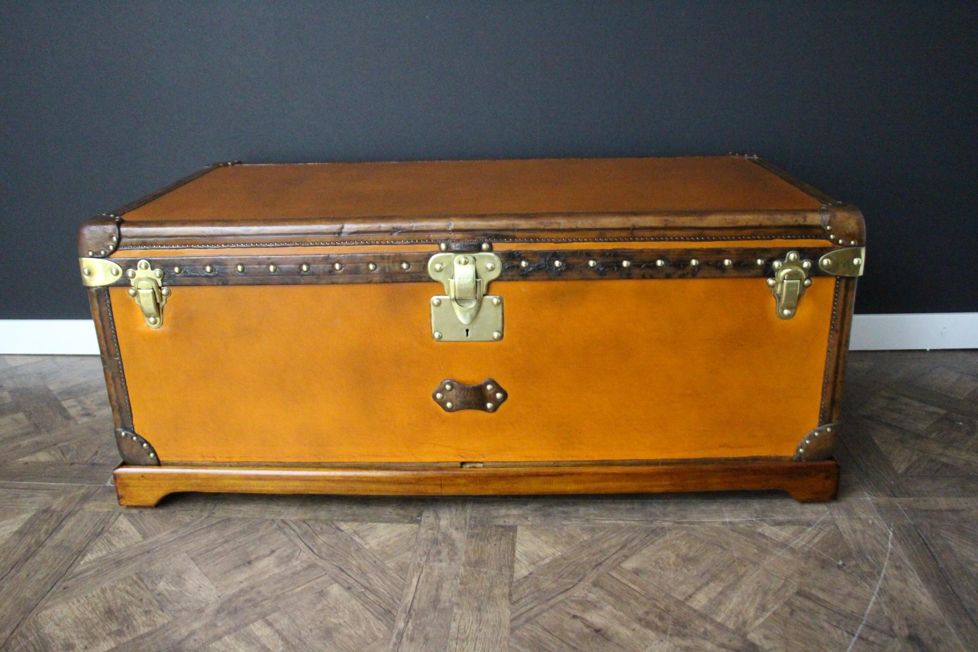 This unusual large Louis Vuitton trunk features beautiful orange canvas, all leather trim in chocolate color, large leather side handles, as well as all Louis Vuitton stamped brass lock, clasps and studs. It has got a very nice and rich patina. 
Its