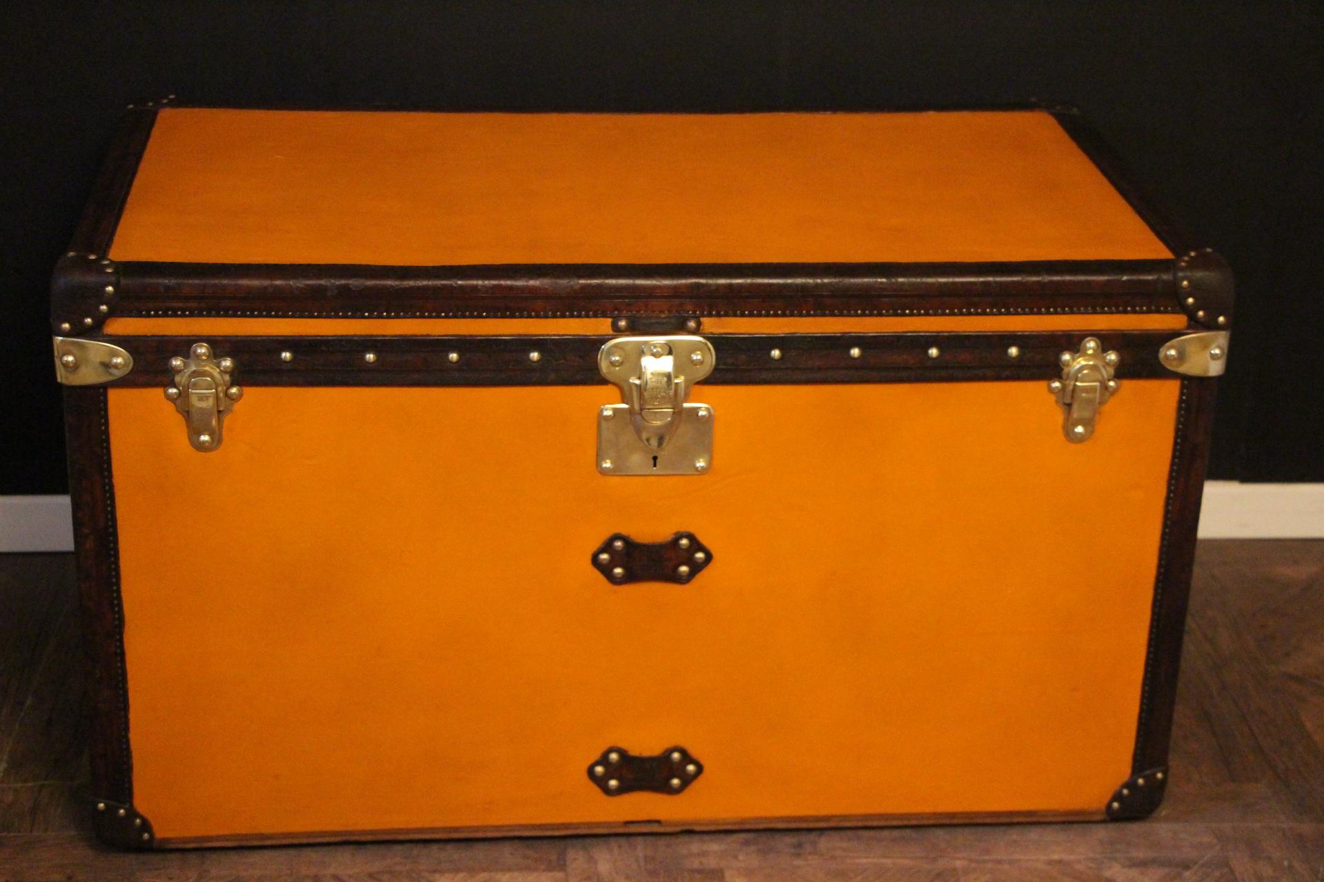 This unusual Louis Vuitton trunk features beautiful orange canvas, all leather trim in chocolate color, large LV embossed leather side handles, as well as all Louis Vuitton stamped brass studs. Dark blue and white customized painted stripes are on