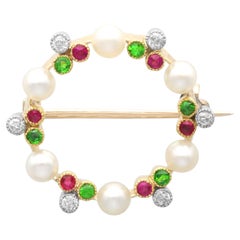 Spilla in oro giallo con perle, diamanti, peridoto e rubino del 1910