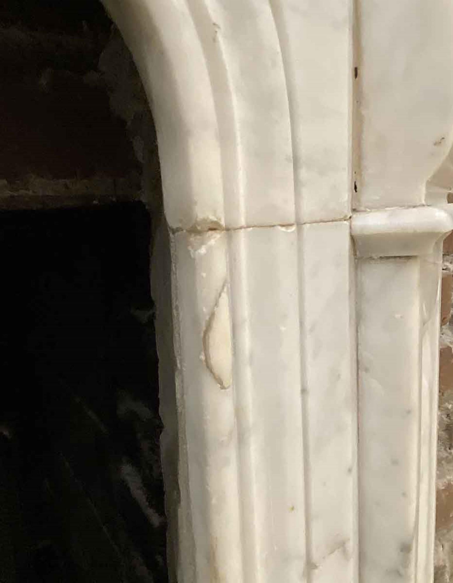 Petite carved French Carrara marble mantel from a West 9th St brownstone in Manhattan. From the 1910s. This can be seen at our 333 West 52nd St location in the Theater District West of Manhattan.