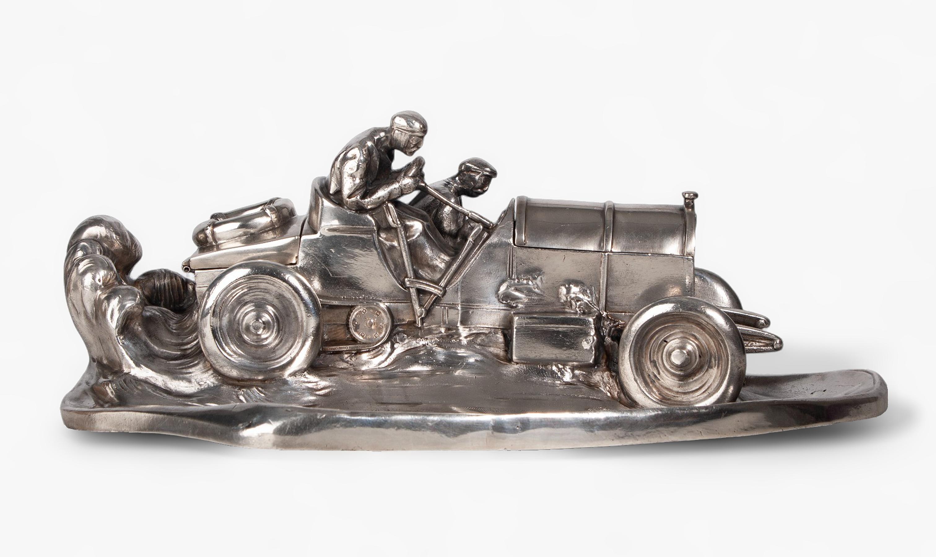 1910s silvered pewter race car team inkwell and pen tray by Wilhelm Zwick for the company Kayserzinn, Germany

By: Wilhelm Zwick, Kayserzinn
Material: pewter, copper, lead, tin, metal, silver
Technique: polished, metalwork, cast, silvered,