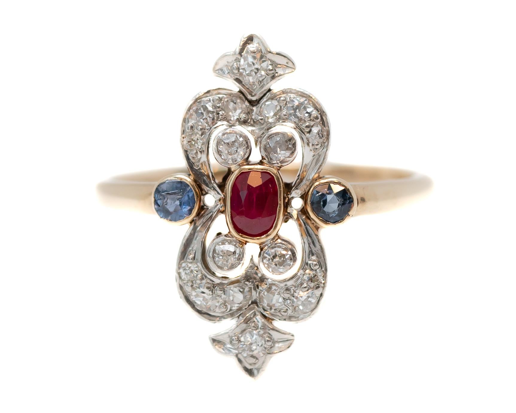 1910s Victorian Era Shield Ring featuring 14 karat Yellow Gold, Platinum, Ruby, Diamonds and Sapphires

Features:
Elongated Cushion cut, Natural Ruby Center Stone, Bezel set 
Round Accent Diamonds, Prong Set, Color: H-I, Clarity: VS-Si
2 Round