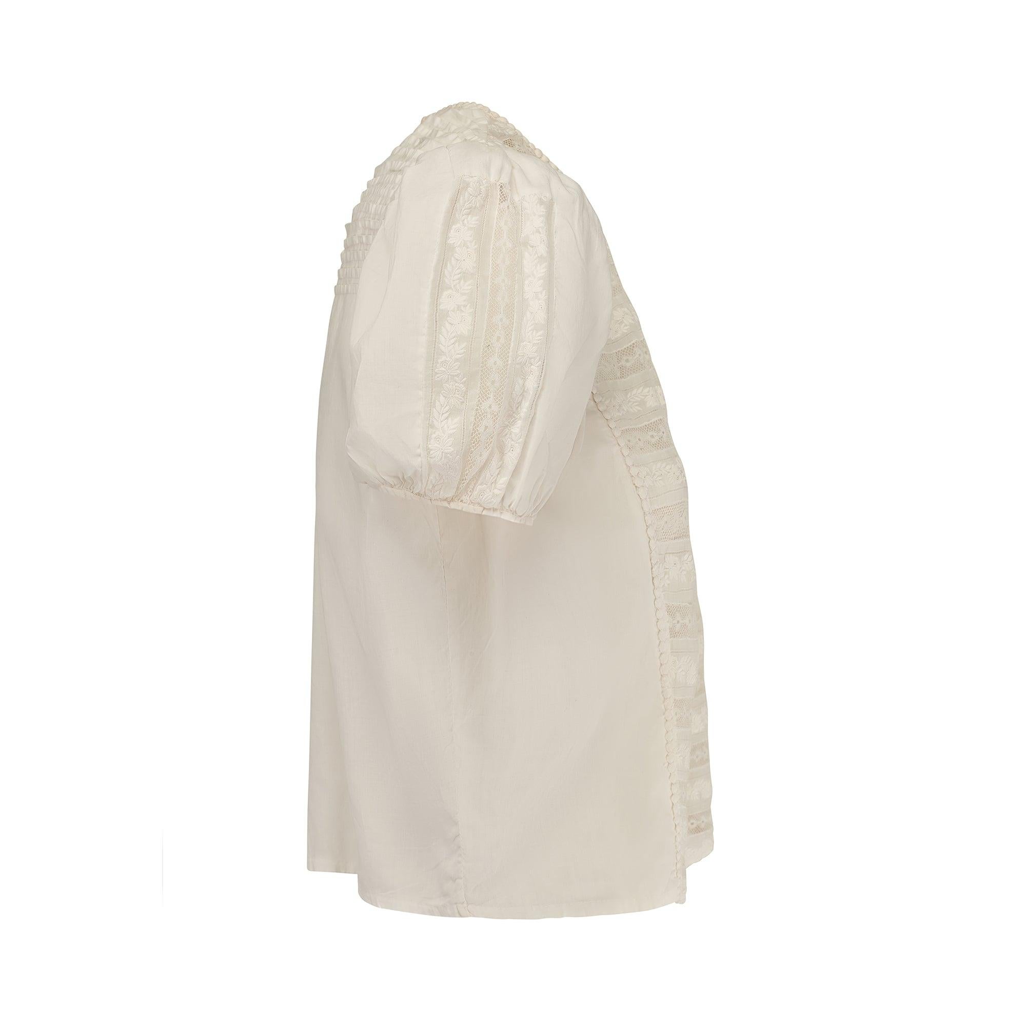Esta original blusa eduardiana es una prenda antigua muy ponible que data de principios del siglo pasado, hacia 1910. El detalle de esta blusa está hecho totalmente a mano con un ligero algodón blanco. La camisa tiene un panel frontal con rayas de