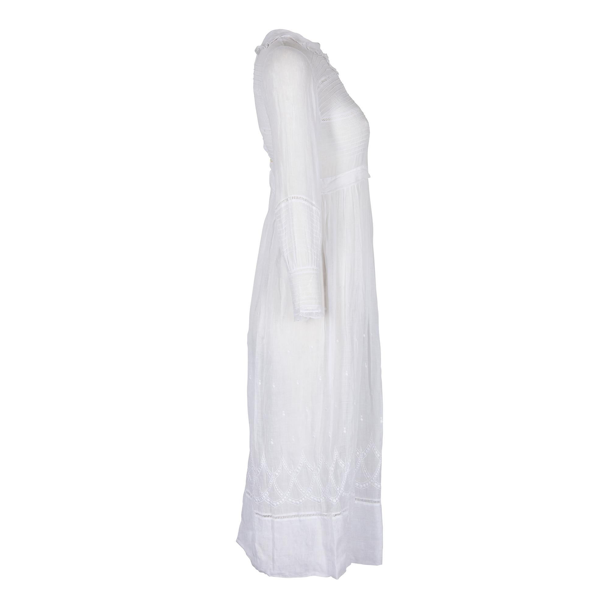This is a very fine handmade Edwardian to early 1910s cotton white cotton mousseline tea dress. It has wonderful design details; the bodice has a series of horizontal pin tuck pleats with exposed rectangular eyelets on the collar bone. These are