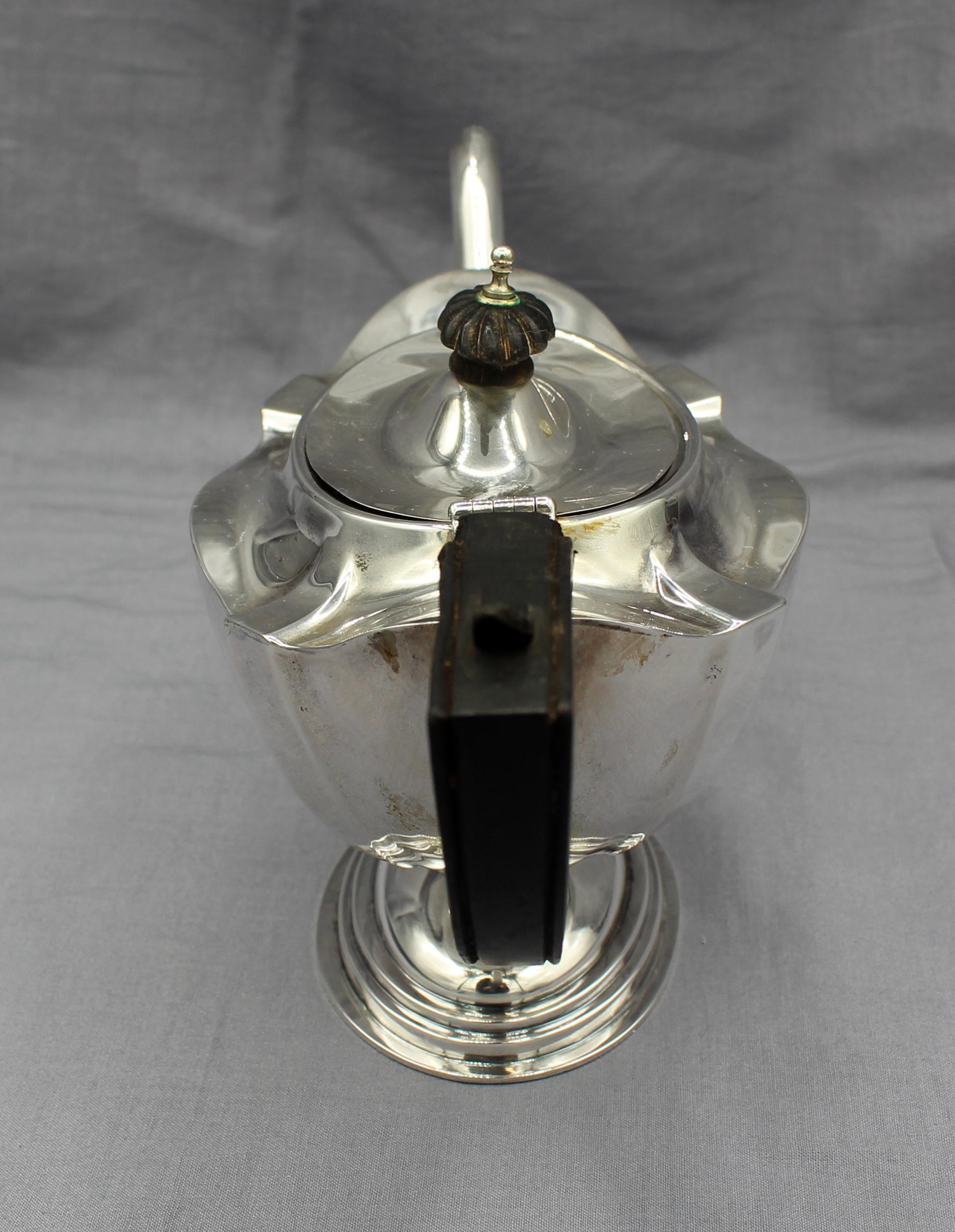 English neoclassical revival sterling tea pot, Birmingham, 1912. Likely by Albert Sydenham. Wooden oval floret knop. Base ring repair, original wooden handle as is. 9.75 troy oz. with fittings.
10.5