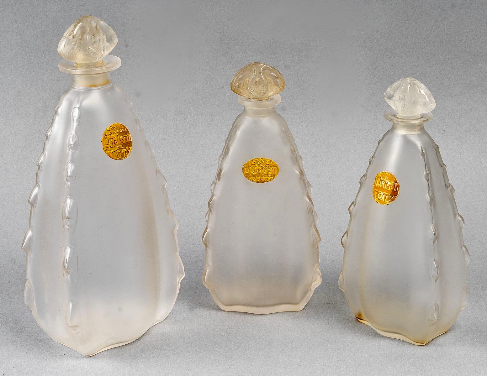 Set of 3 perfume bottles “L'Origan” made in frosted glass by René Lalique for Coty in 1912.
Signature molded under one bottle.

The 3 bottles are in perfect condition.

A 23.5 cm high bottle with the label “Eau de Cologne Origan de Coty”.
A 19