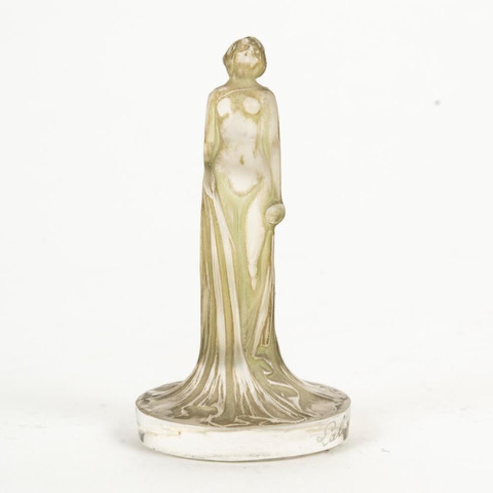 René LALIQUE (1860-1945)
“Draped statuette” seal in pressed molded white glass  and enhanced with a  slightly green patina , mold no. 699 

model created in 1912 signed “Lalique” on the edge with a stylus .

H: 6.3 cm 

Bibliography: Félix