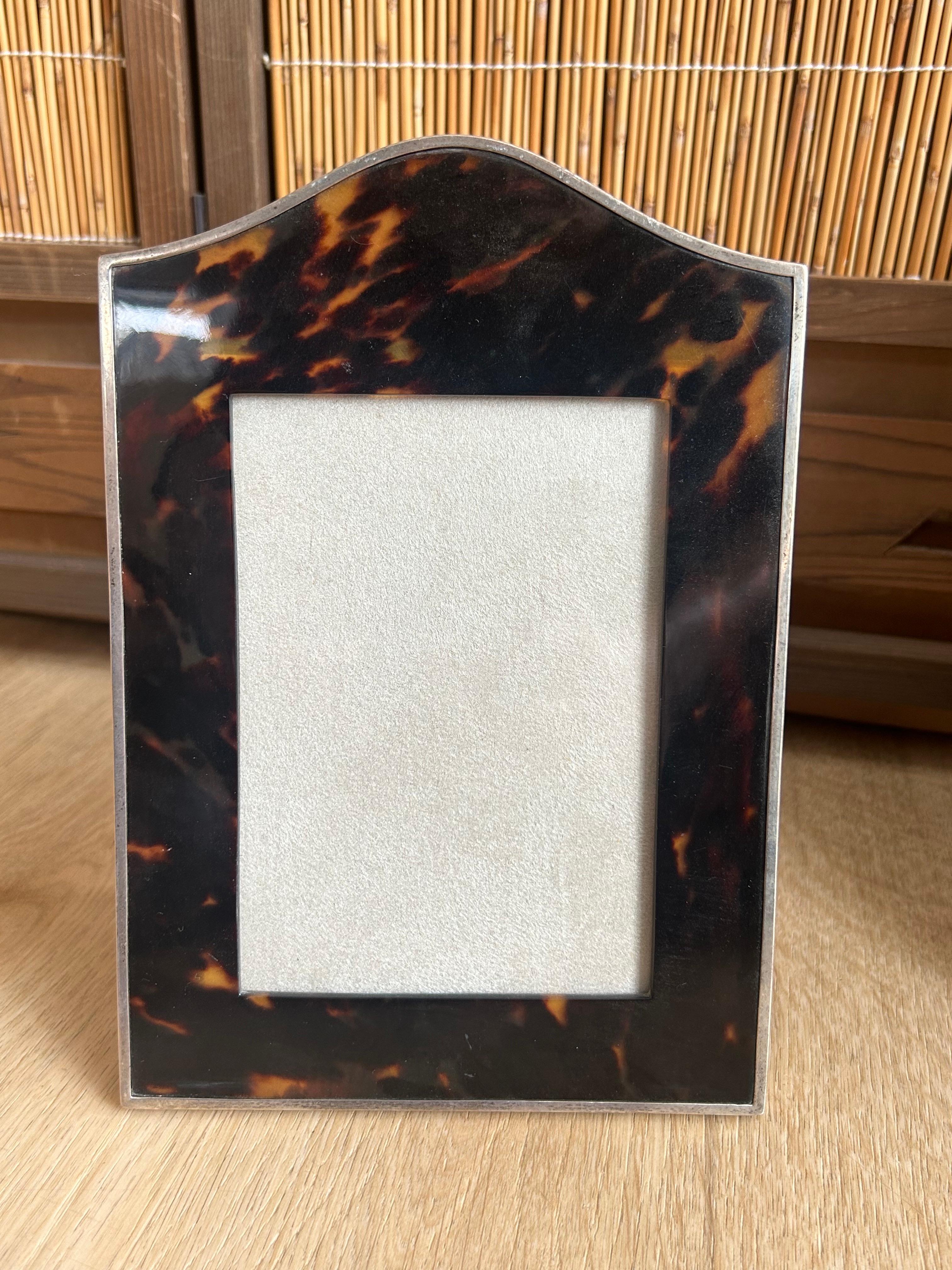 One tortoiseshell Photograph Frames with silver rims and suede backings.
A Photograph Frame with arched top, London 1913, mark of W.C for William Comyns & Sons Ltd

The pictures are part of the description

Warning: Since this items are made of a