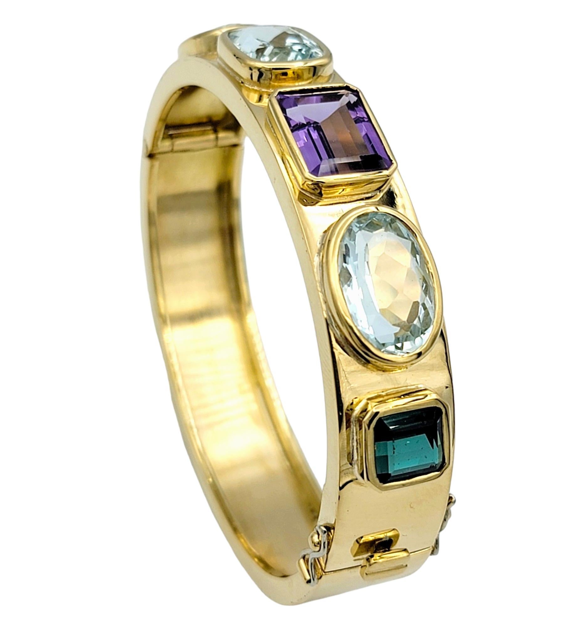 Rehaussez votre poignet avec cet époustouflant bracelet à charnière en or jaune 18 carats, orné de plusieurs pierres précieuses. Chacune des cinq pierres précieuses vibrantes - améthyste, aigue-marine et tourmaline verte - est méticuleusement