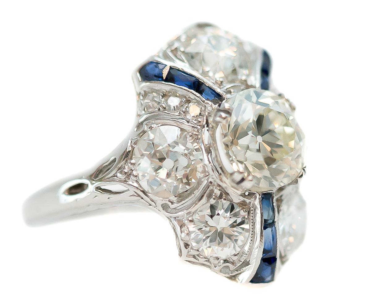 GIA 1915 Antique Diamond Engagement Ring - Platinum, Diamonds, Natural Blue Sapphire

Features:
1.07 carat Old European Brilliant Diamond Center Stone
2.23 carat total Old Miner Diamond Side Stones
6 French cut Baguette and 3 Modified French cut