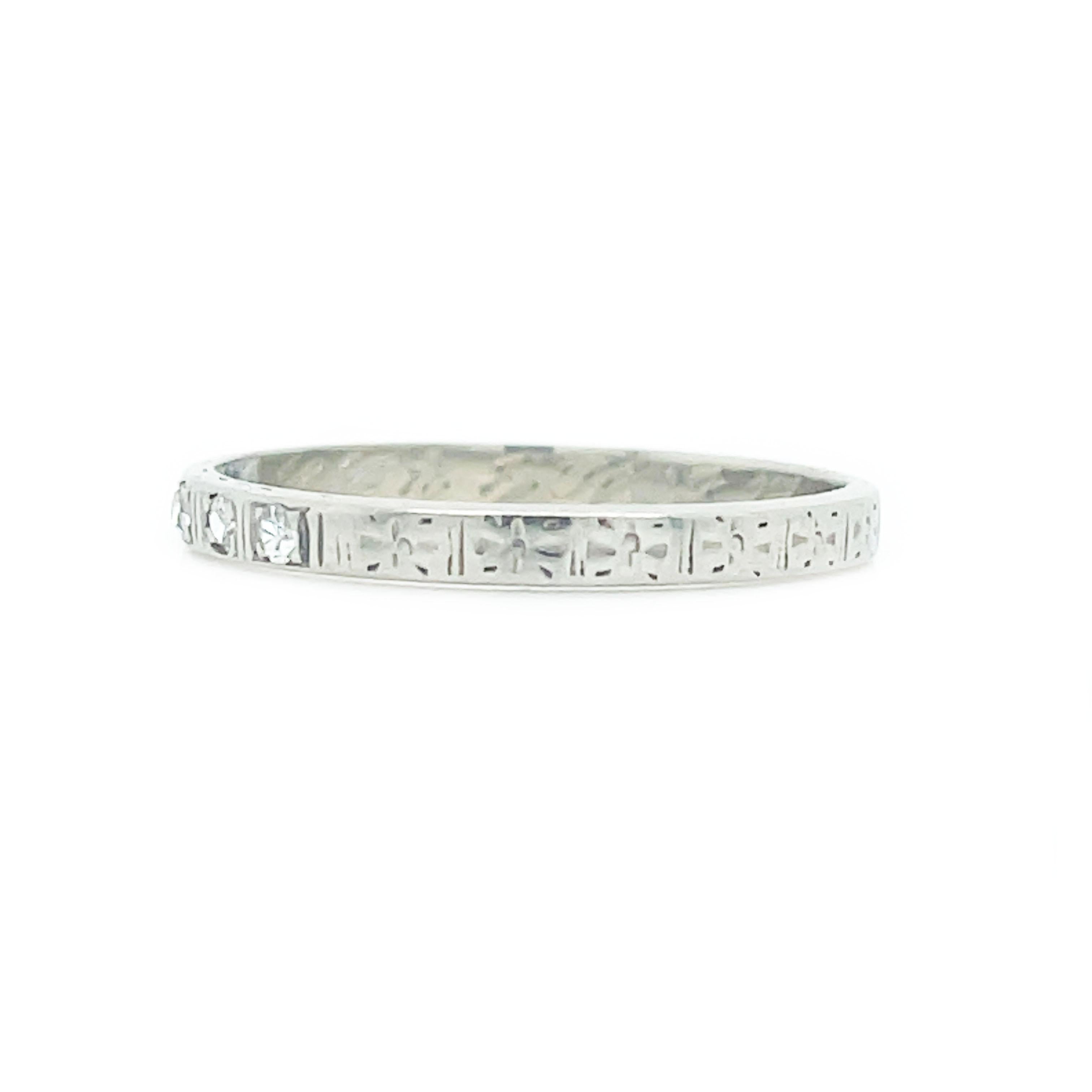 This is a lovely Art Deco band set in 18K white gold that features gorgeous hand engraving and five sparkling diamonds! Hand engraved with tiny starbursts, this elegant wedding band twinkles with five scintillating single-cut diamonds. A perfect