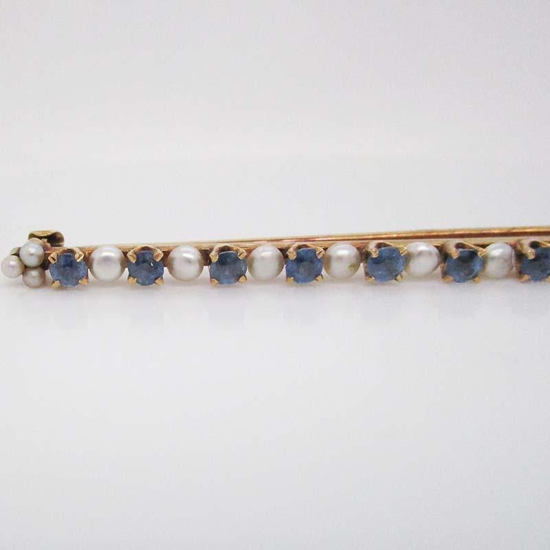 This Art Deco bar pin is from 1915 and brings together rich 14k yellow gold, soft white natural pearls, and stunning steely blue Montana sapphires! The combination of white pearl and gorgeous Caribbean blue sapphire, set in a linear design makes for