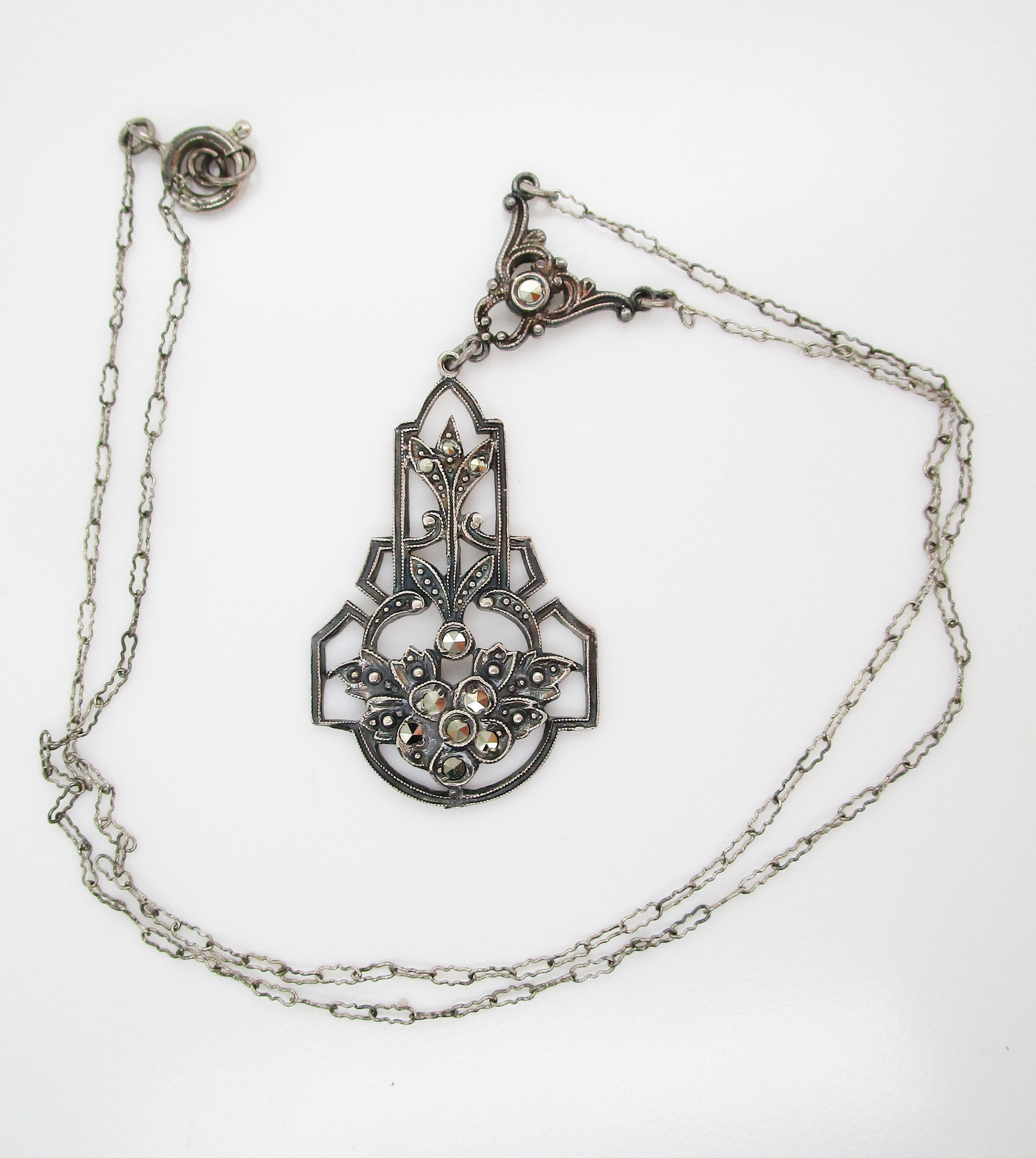 This delicate Art Deco necklace is from 1915 and simply oozes antique charm-with its warm sterling silver and flashing marcasite stones, it is truly remarkable! The dramatic, articulated center of the necklace features a cutout floral design