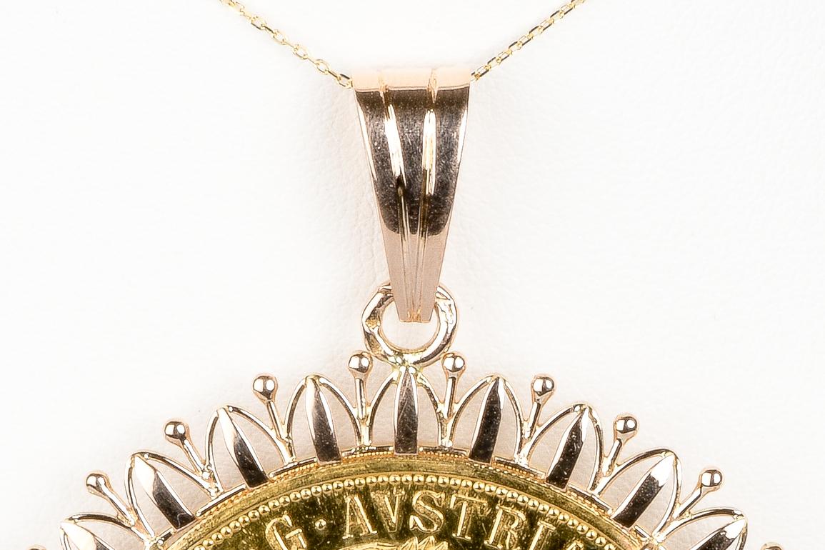 This necklace is composed of a delicate fine mesh chain that highlights a round locket pendant in 18k gold. This pendant is set with a real gold piece 23 3/4 carats. The ducat is an ancient gold currency originally circulating in Middle Ages Europe