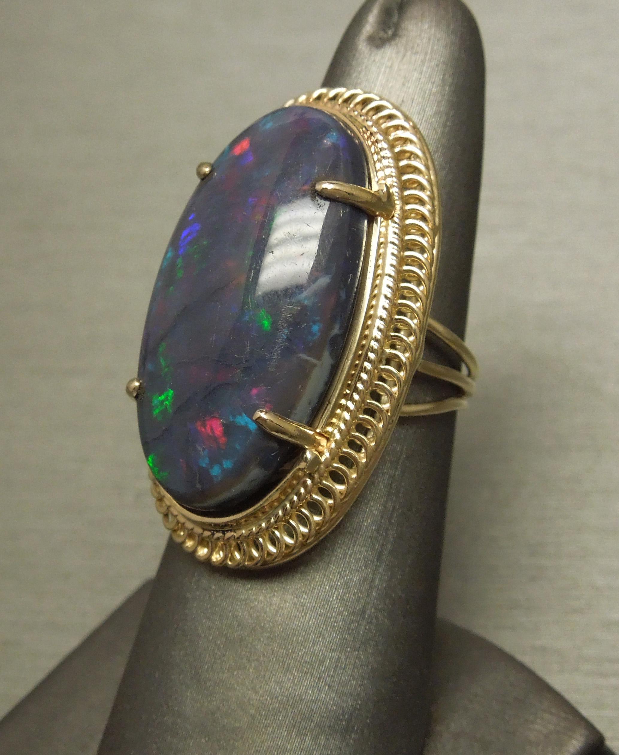 Cette bague solitaire en opale opulente présente une opale noire de 19,15 carats certifiée par le GIA, qui possède toutes les caractéristiques d'une opale prisée par un collectionneur d'opales ! Avec une dispersion symétrique et équilibrée des