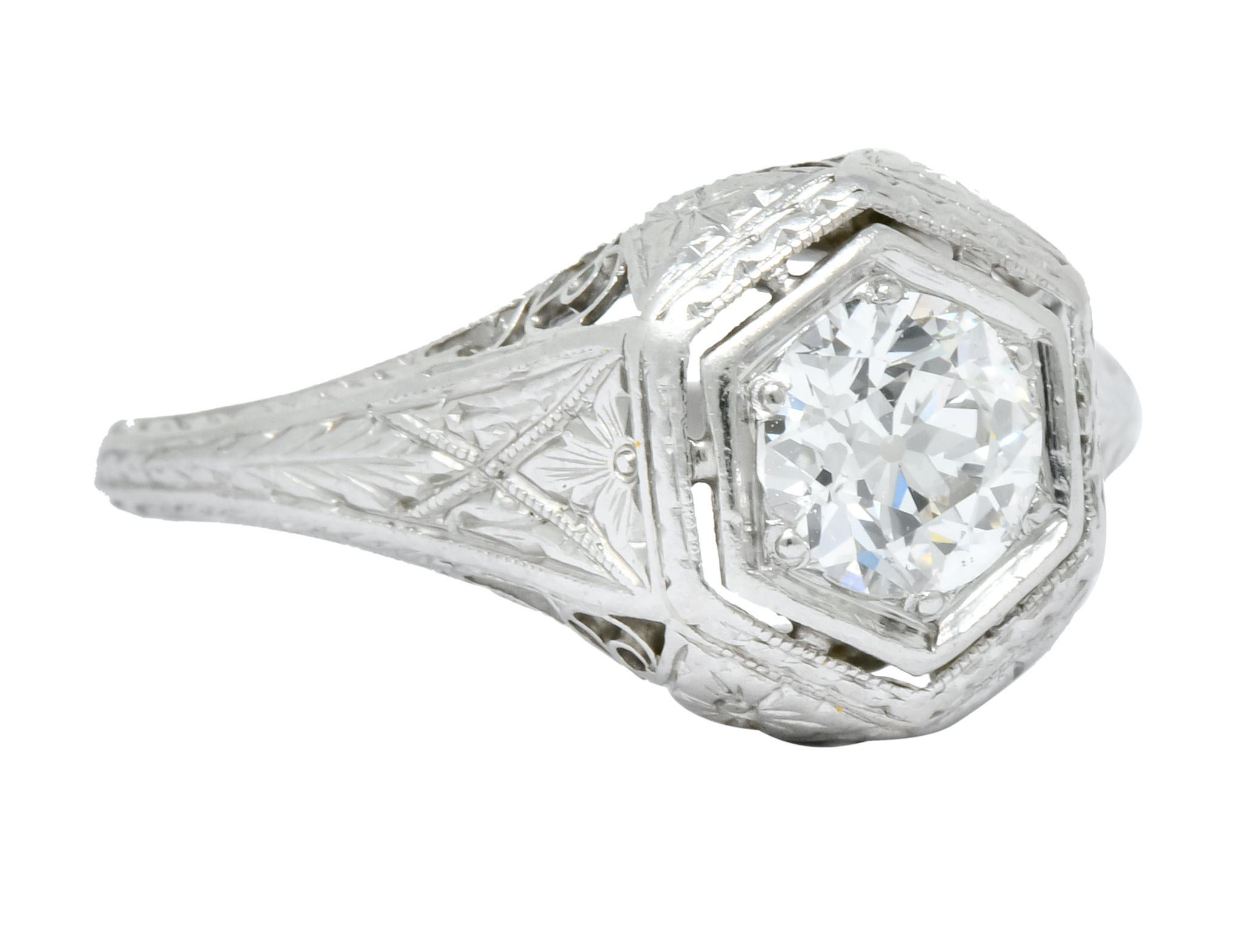 Centering an old European cut diamond weighing approximately 0.63 carat, I color and VS clarity

Prong set in a hexagonal mount with engraved floral gallery and pierced details

With engraved foliate motif on shoulders and partially down