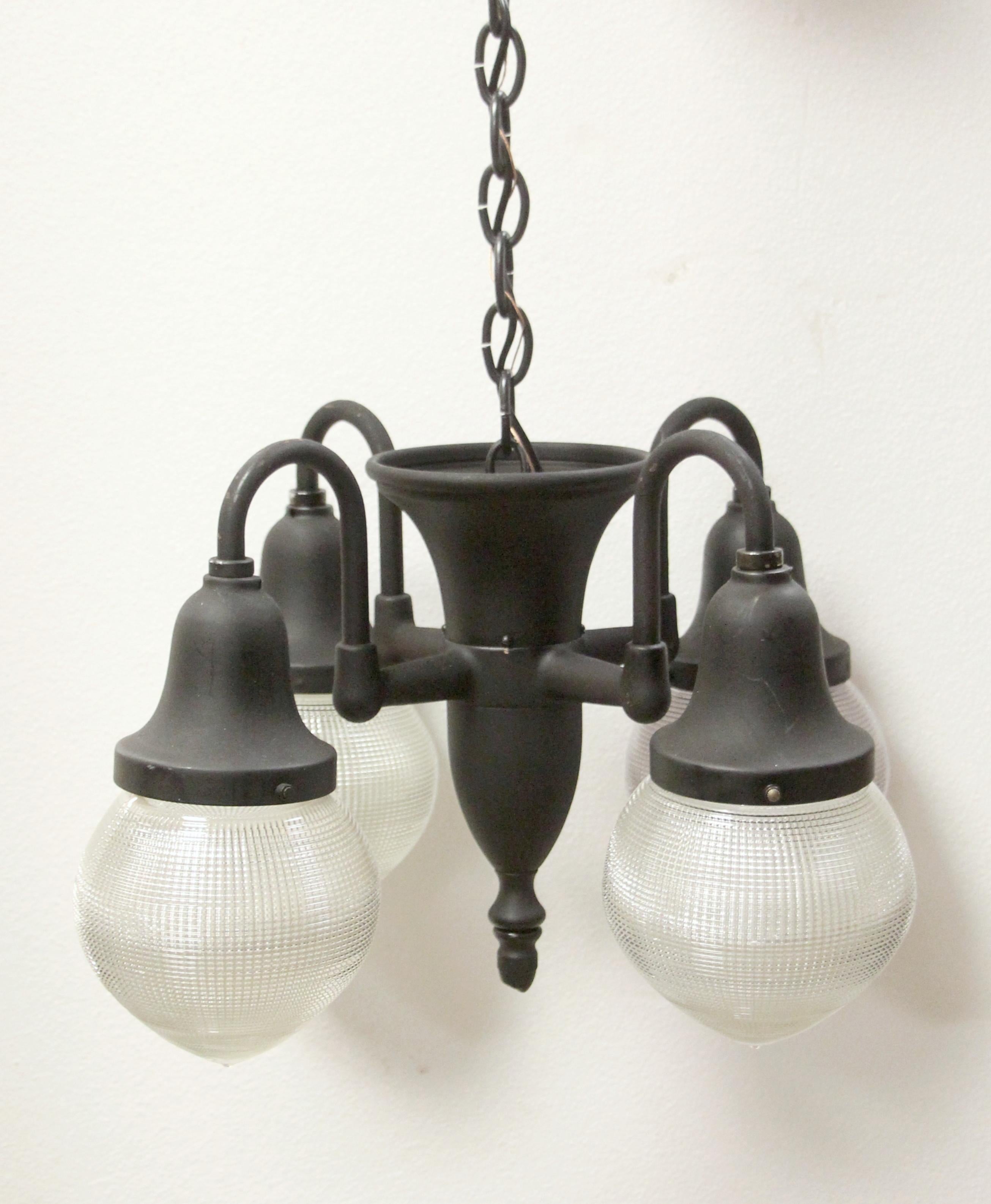 Original 1915 brass dental or Industrial pendant light with a black finish and the four original Holophane down light shades. This has been fully restored with a long brass chain and canopy. This can be seen at our 302 Bowery location in NoHo in