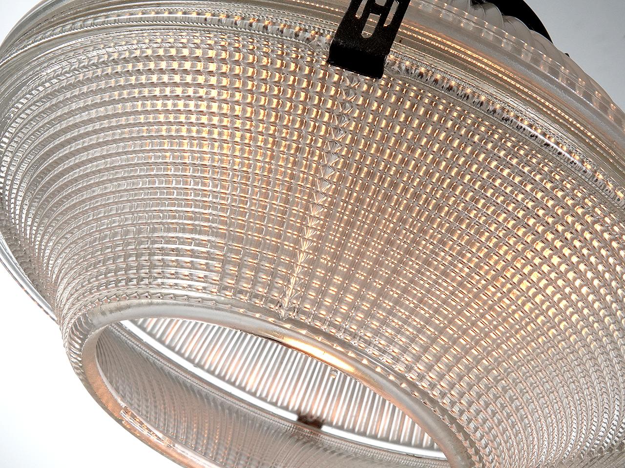 Nous aimons les lampes Holophane pour la merveilleuse lumière qu'elles projettent. Le verre est entièrement prismatique et conçu pour tirer le meilleur parti d'une ampoule. Il s'agit de l'un des premiers modèles de l'entreprise. Nous disposons d'une
