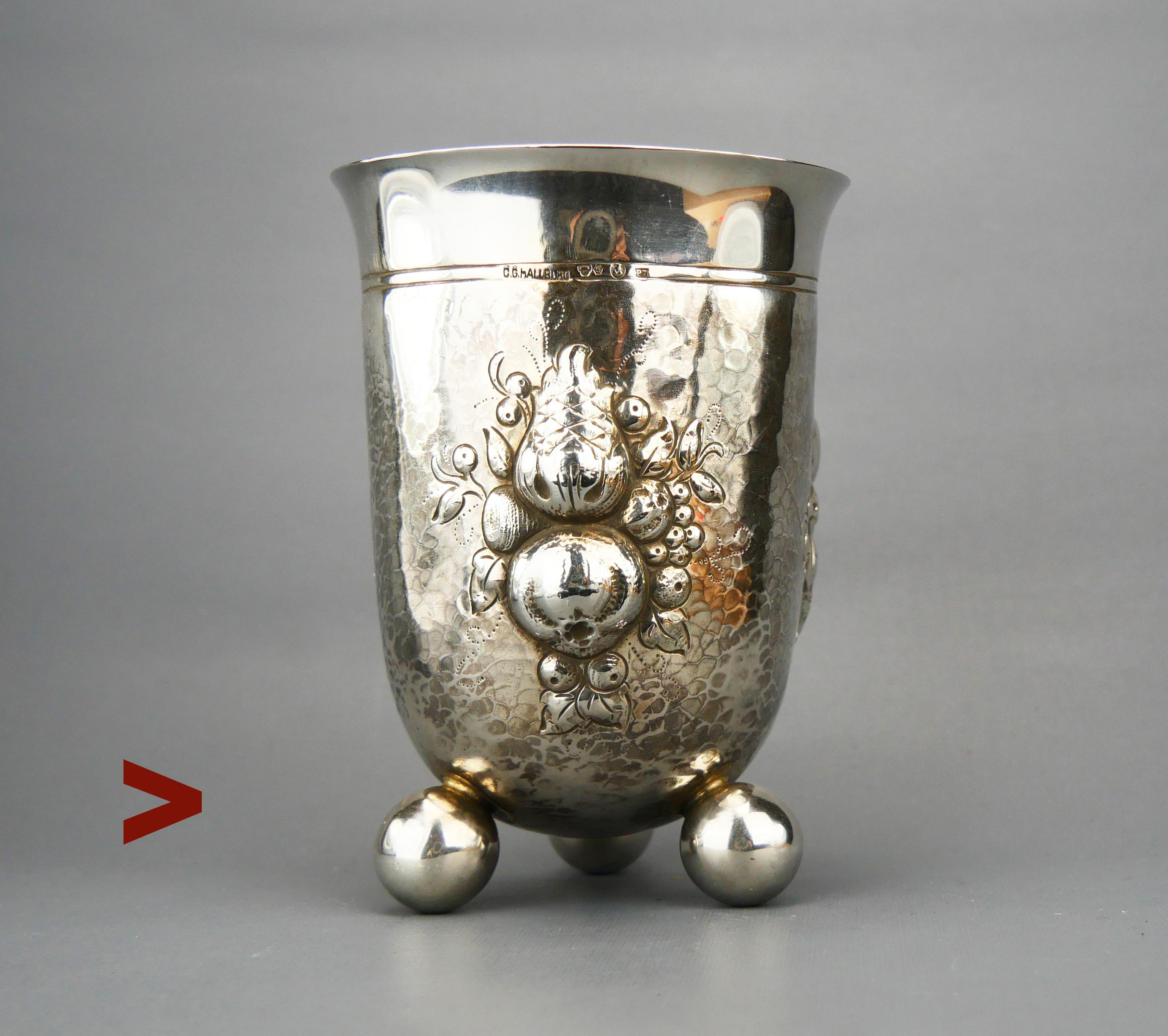 Bellissima tazza svedese fatta a mano su tre piedi a forma di palla. Pareti spesse e solide decorate con ornamenti di frutta e foglie sia martellate che incise.

Punzoni svedesi che confermano almeno l'830 Lega d'argento, tre corone e logo della