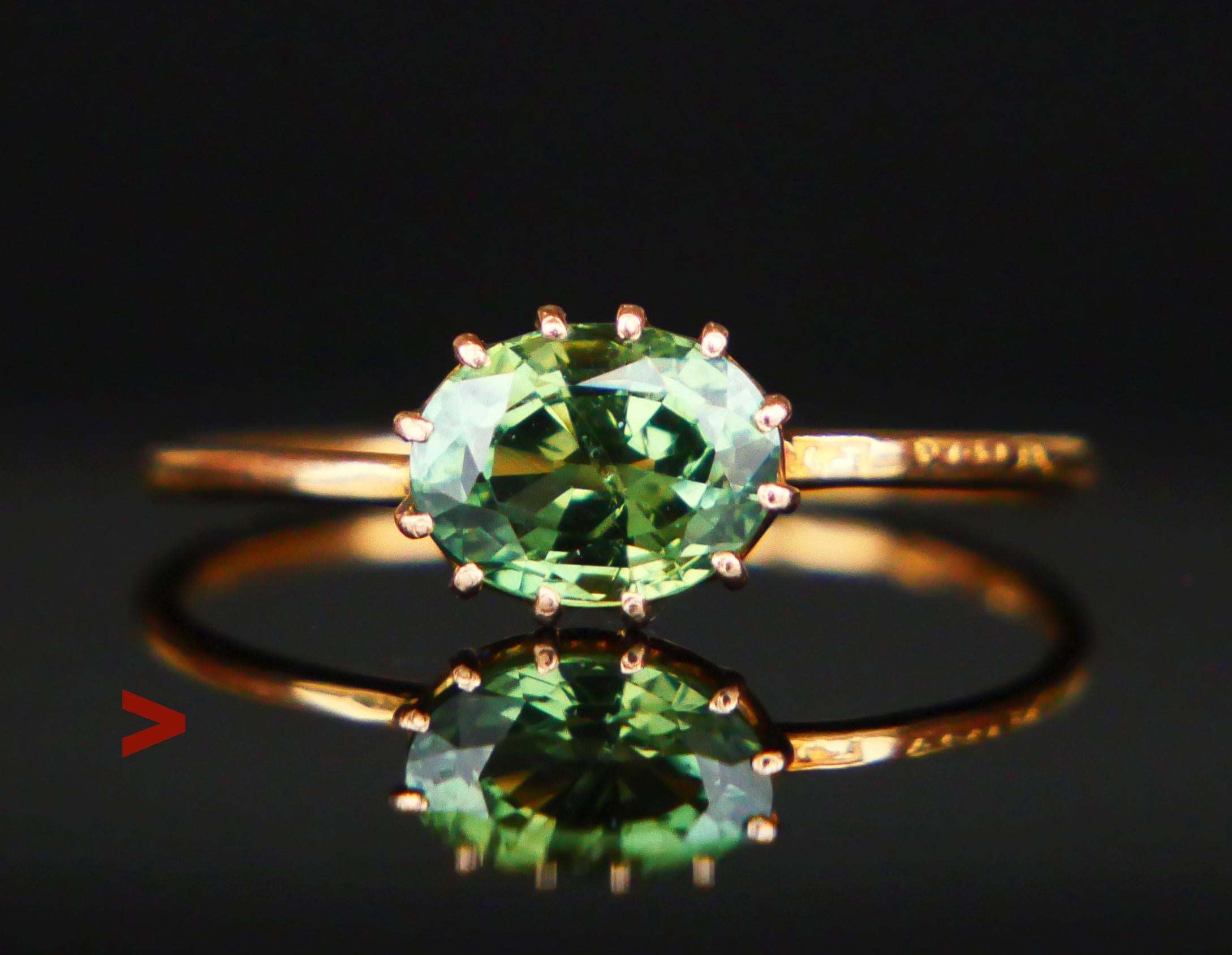 A Ring with plain band featuring a claw set natural Green Sapphire of oval cut 7 mm x 5.5 mmx 3.8 mm deep / ca. 1.4 ct. Green Color of medium intensity, transparent stone - demonstrates internal structure typical for natural stones.. Likely of