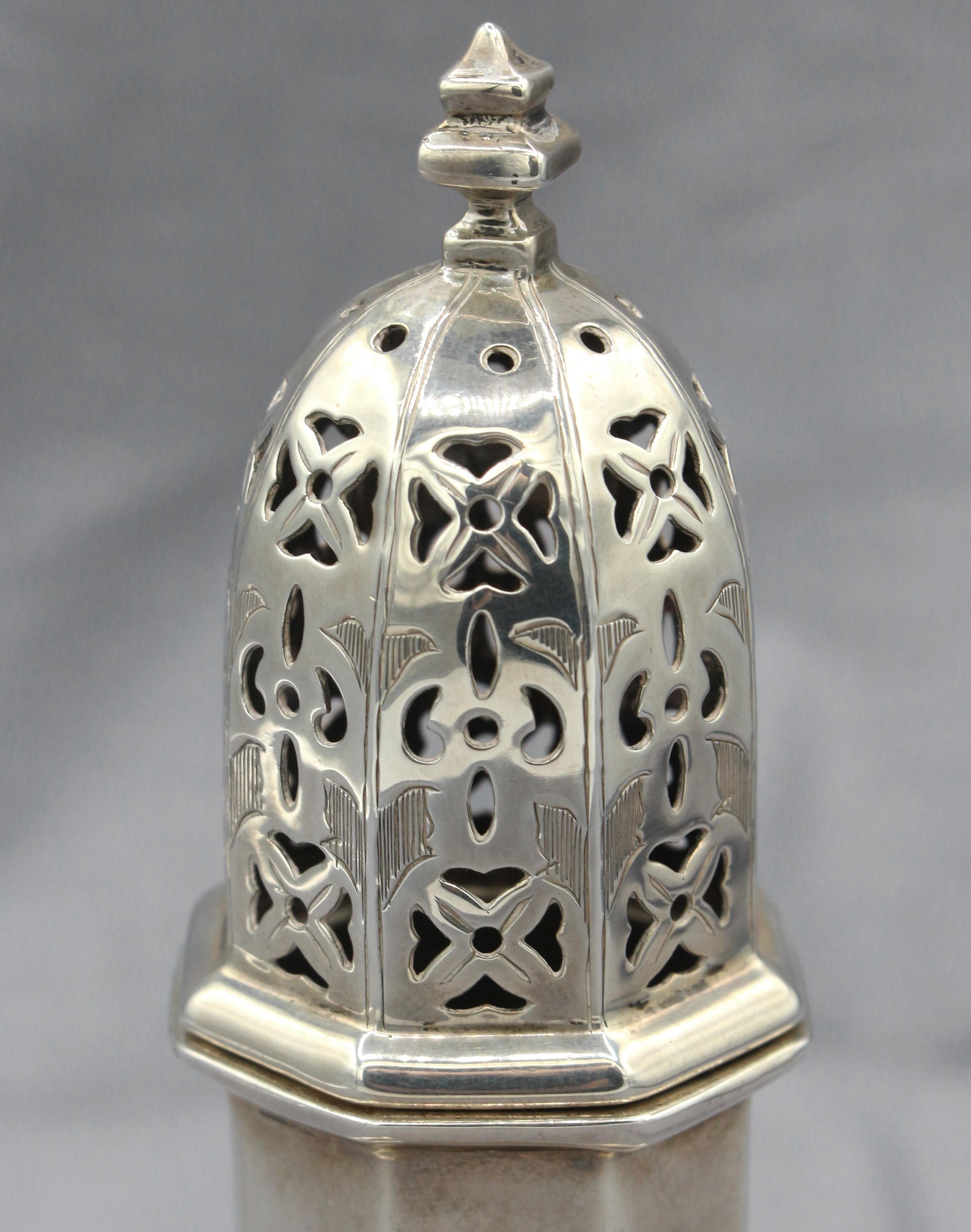 English sterling silver sugar caster by Goldsmiths & Silversmiths of London in 1917. Known for fine Georgian reproductions, this is a superb example with octagonal body, stepped base & pierced & bright cut cover. 4.20 troy oz. 
6.25