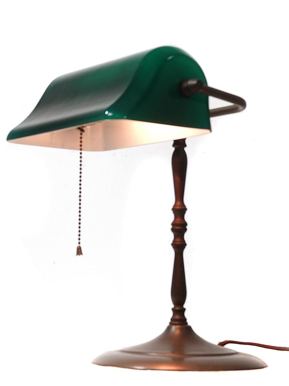 The lamp is not signed but most likely the maker was Verdelite, 1917. This Beautiful banker's desk lamp or piano lamp has an original emerald green blown glass shade.  This example is all original and untouched.