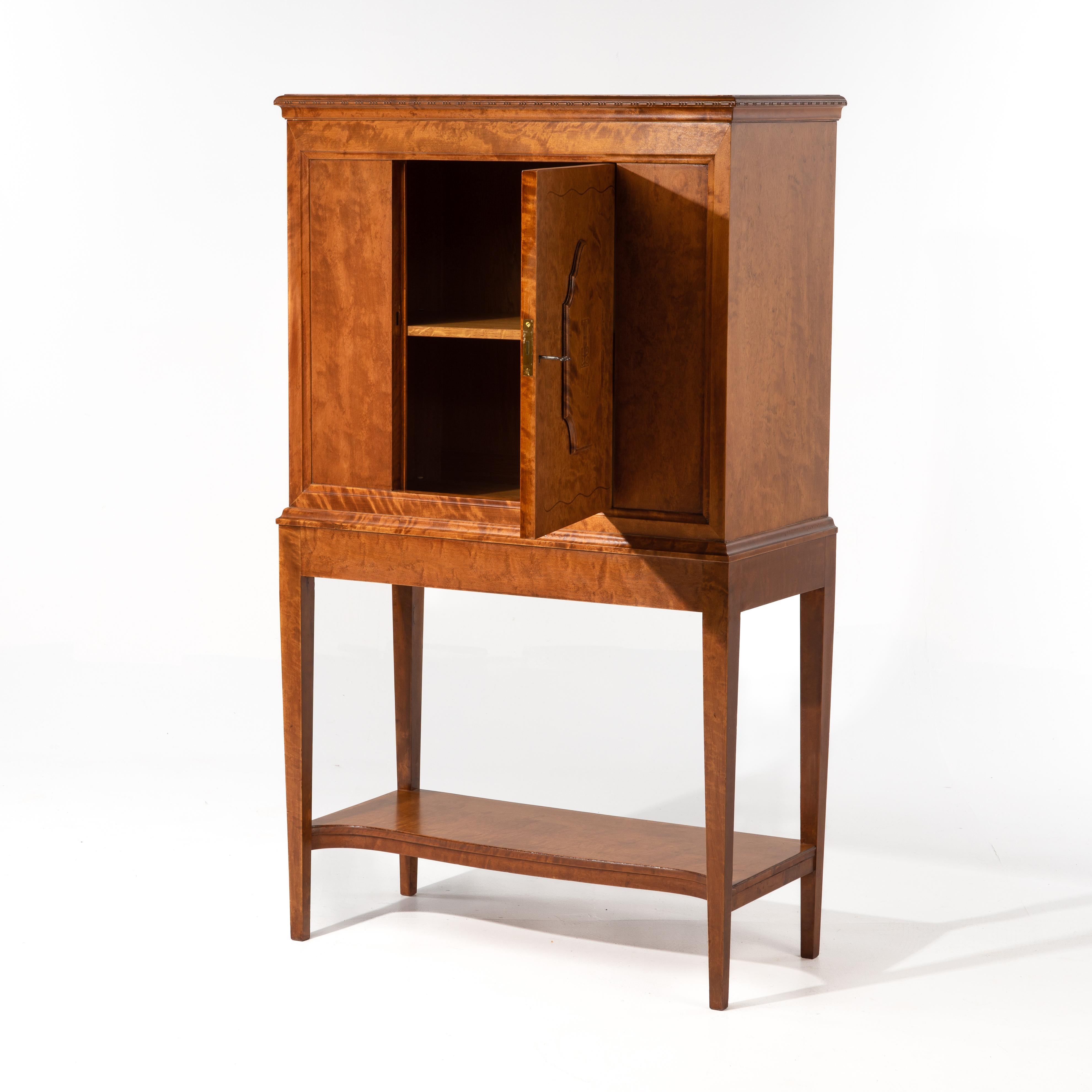 This early cabinet is by A. B. Nordiska Kompaniet attributed to Carl Bergsten, 1918. Figural birch with inlay. The door opening is 12.5
