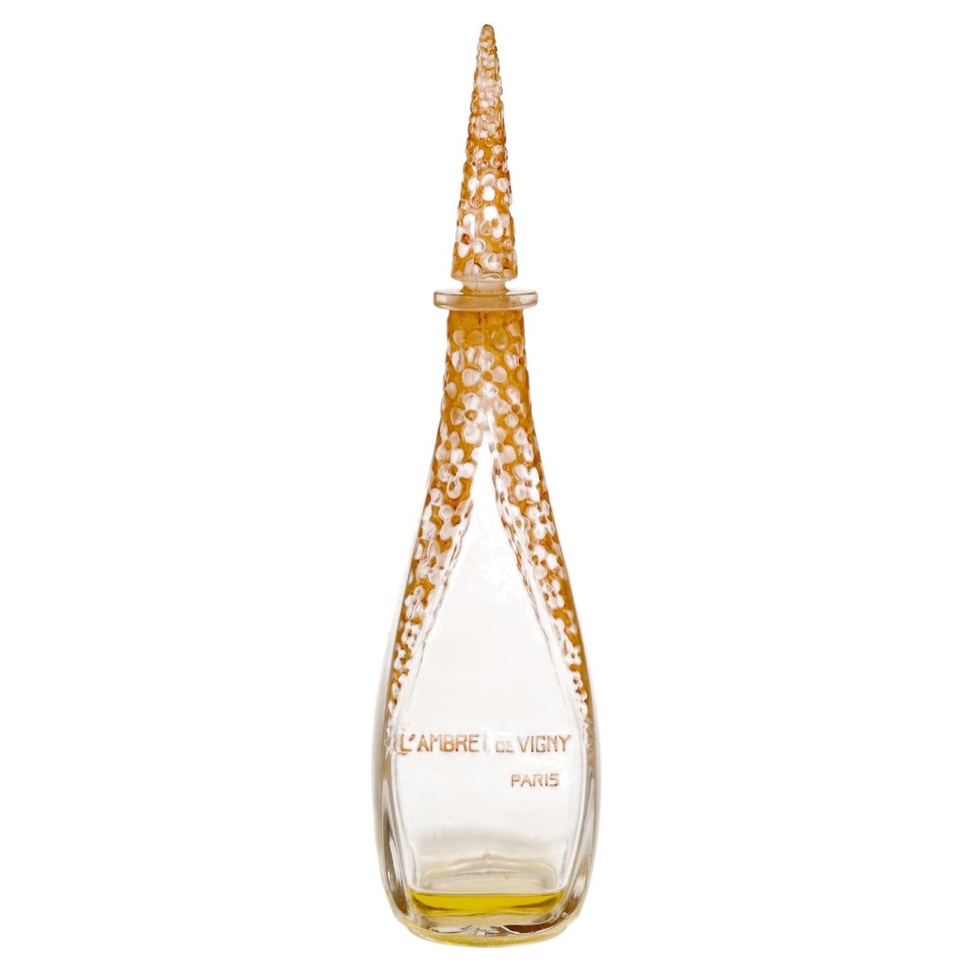 Flacon de parfum René Lalique de 1919 « L'Ambre de Vigny », en verre avec une patine sépia