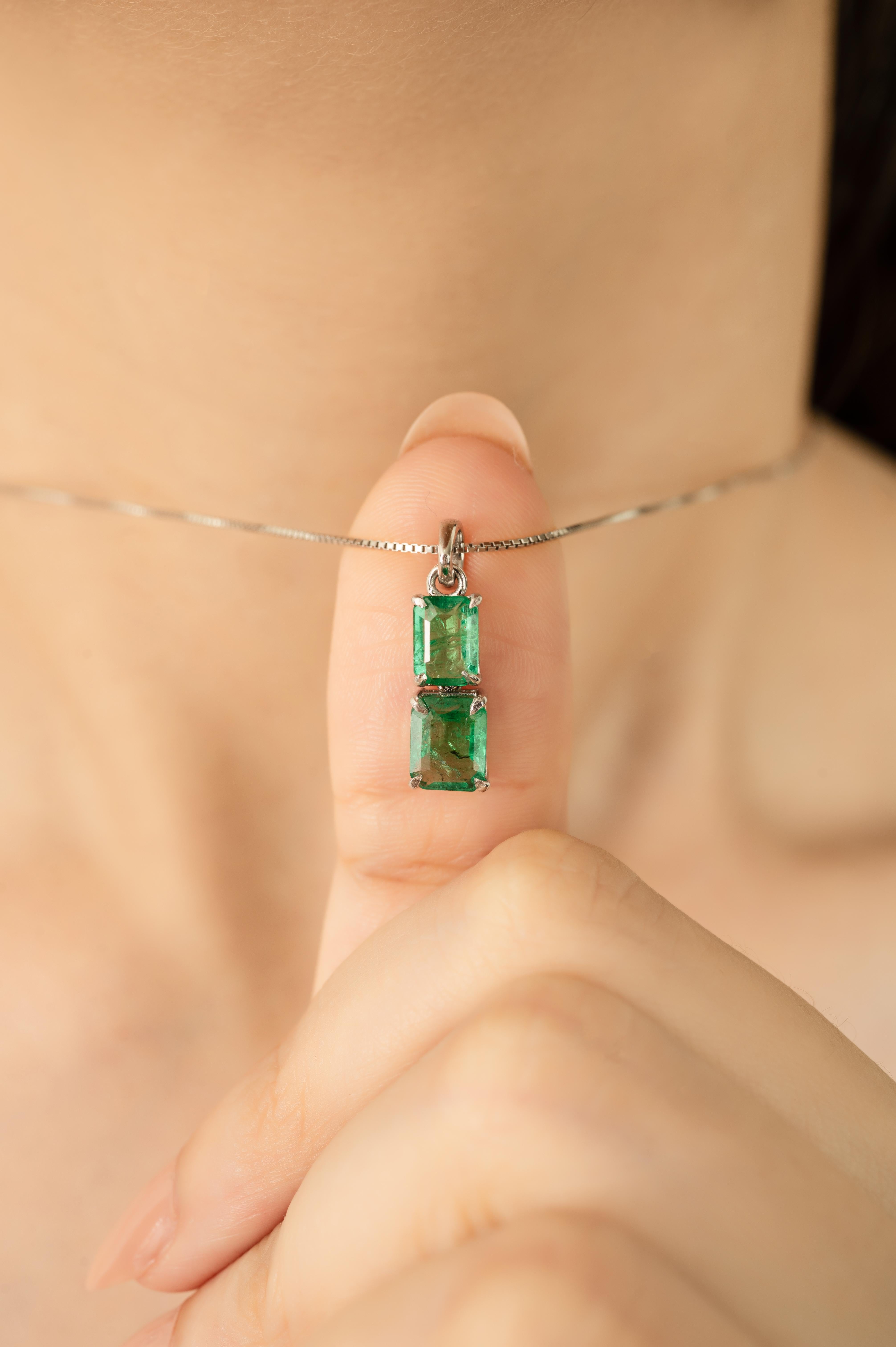 Dieser elegante 1,91 Karat schwere Smaragd-Anhänger mit zwei Steinen besteht aus natürlichen Smaragden im Oktagon-Schliff, die vertikal in einer klassischen 4-Zacken-Fassung angeordnet sind. Jeder Stein ist sicher in 14 Karat massivem Weißgold