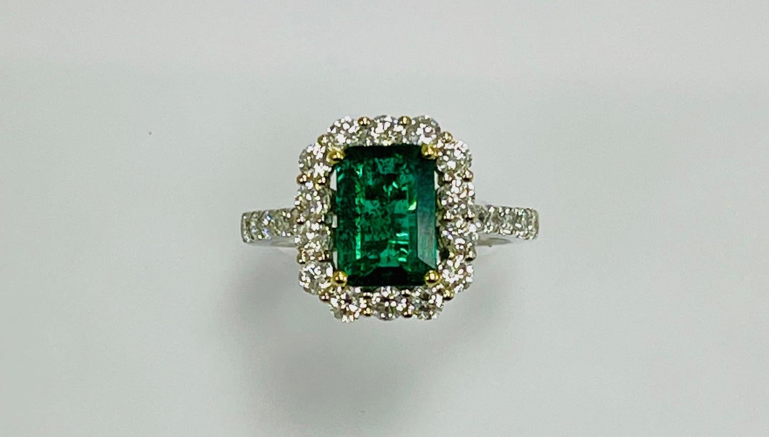 1.92 Carat Zambian emerald cut emerald set in 18k white gold ring 1.07 Carat diamonds around it and hlaf way on the shank .