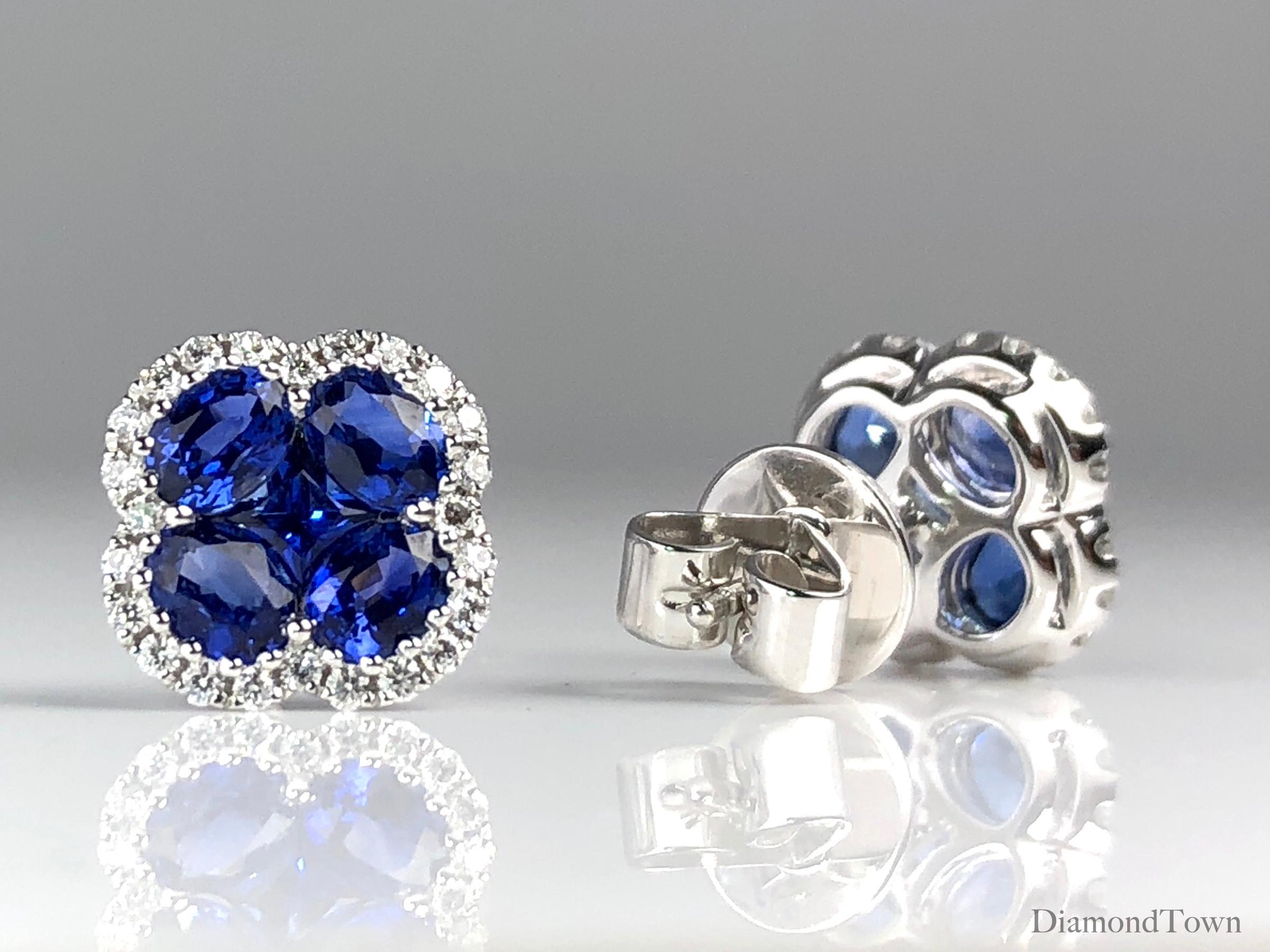 Diese wunderschönen Ohrringe zeigen ein Kleeblattdesign aus vier oval geschliffenen und einem prinzessgeschliffenen lebhaften blauen Saphiren (Gesamtgewicht 1::92 Karat):: umgeben von einem Halo aus runden Diamanten (Gesamtgewicht 0::23 Karat). 

Zu