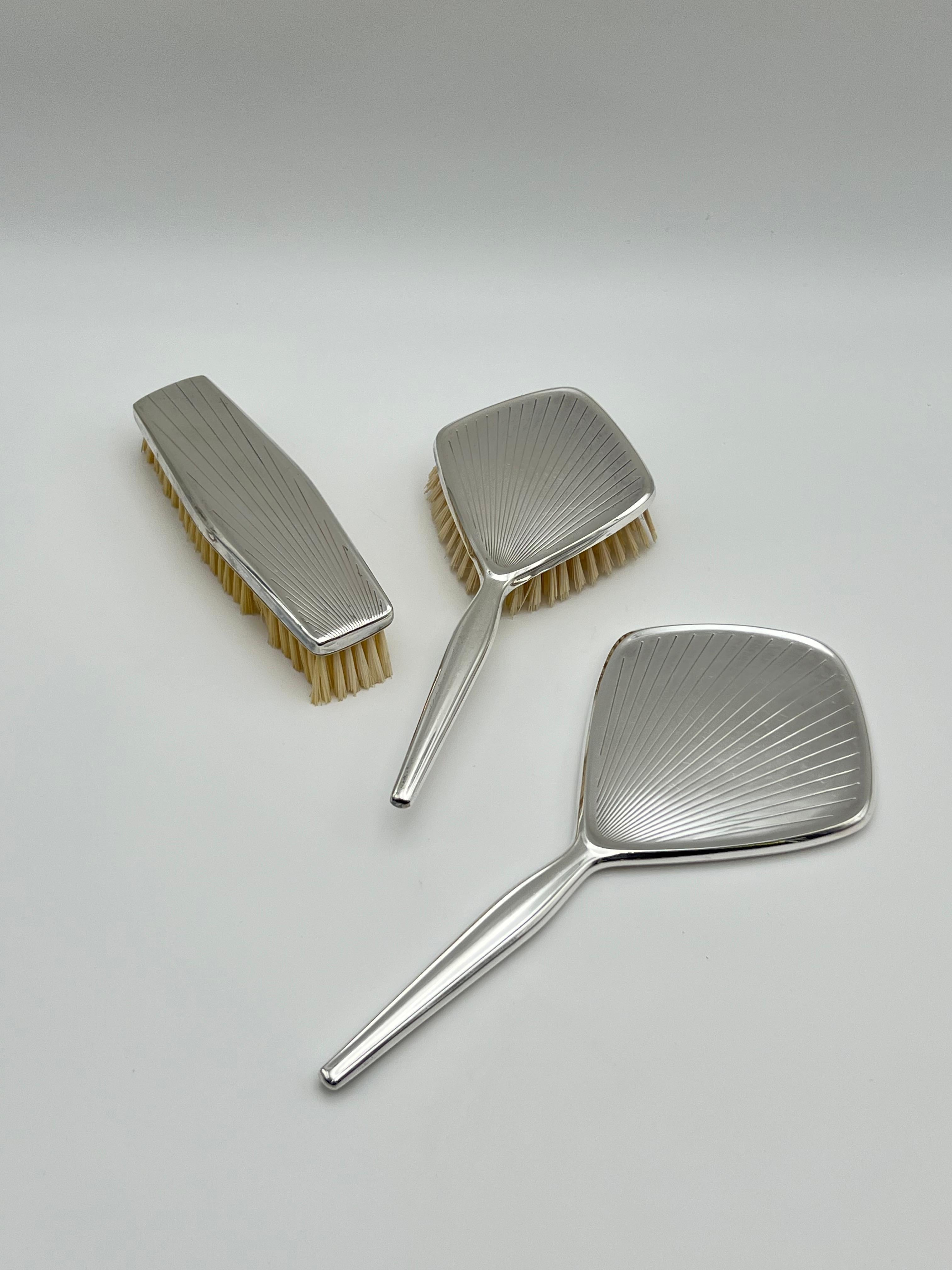 Impresionante tocador antiguo de estilo ART DECO de hacia 1920/30. Plata / Plateado, de Hoka, Alemania

Dimensiones ca: 
--Espejo: 28 x 12,5 cm,
--Pincel con mango: 22,5 x 10 cm,
--Pincel: 16,5 x 4,5 cm. 

En buen / muy buen estado antiguo, con
