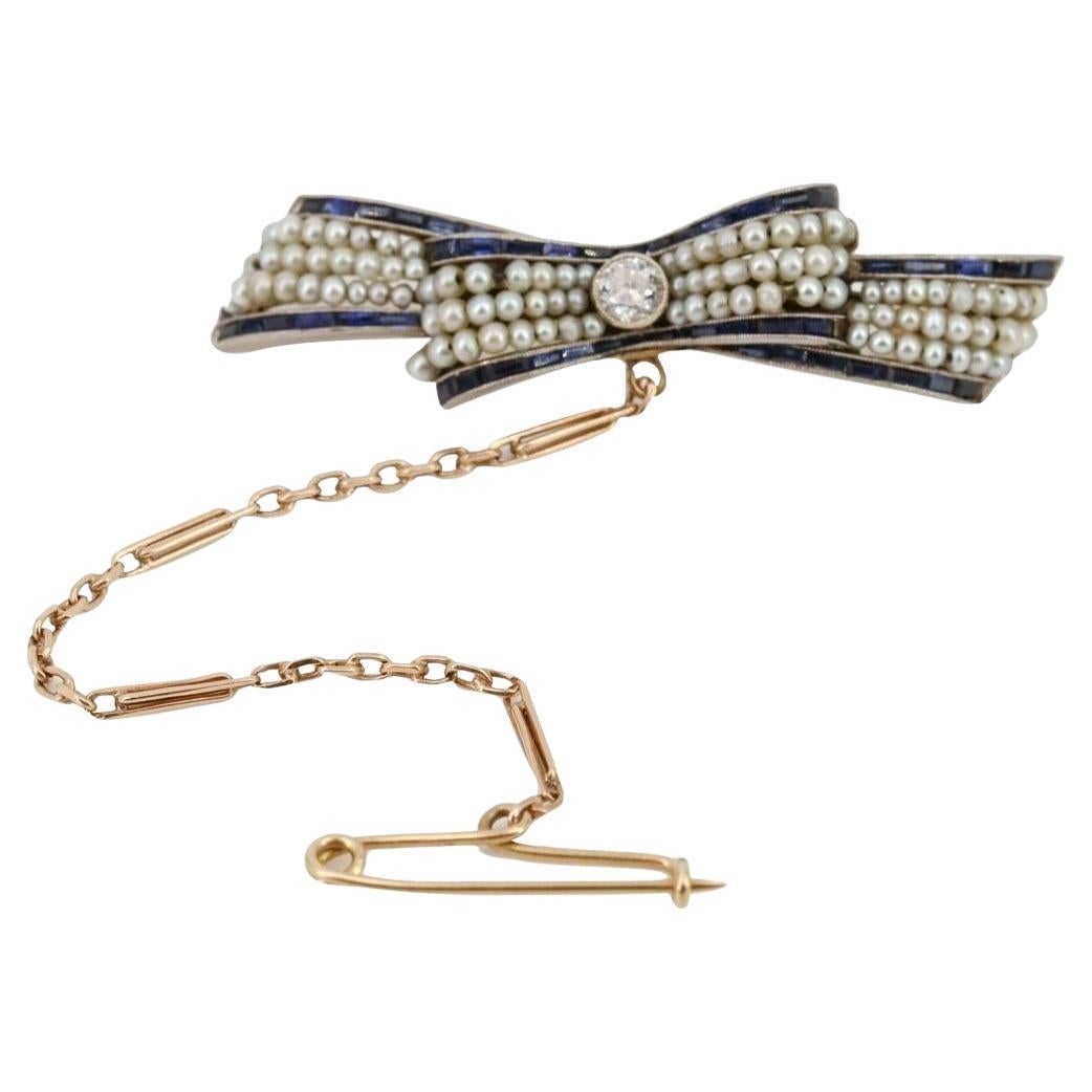 1920 Art Deco 18k Gold Bow Brooch with Diamonds, Sapphires 
Natural Pearls (Broche nœud en or 18k avec diamants, saphirs et perles naturelles) en vente