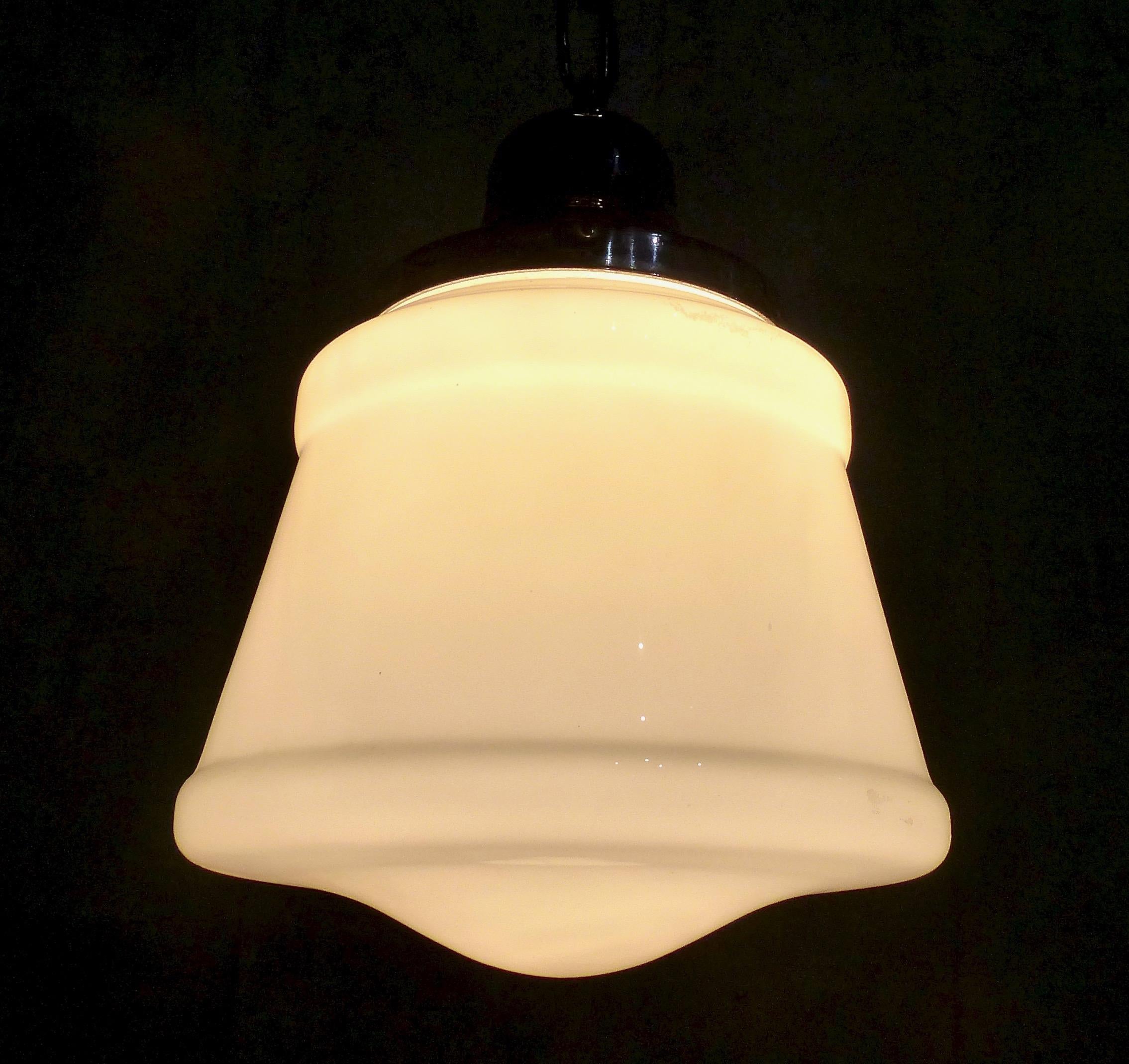 Classic Art Deco milk glass shade with chrome fitter. Re-wired and CSA approved to current electrical standards; ceiling mounting plate included. Currently hangs at 24” but could be adjusted to meet your needs. We currently have six shades in this