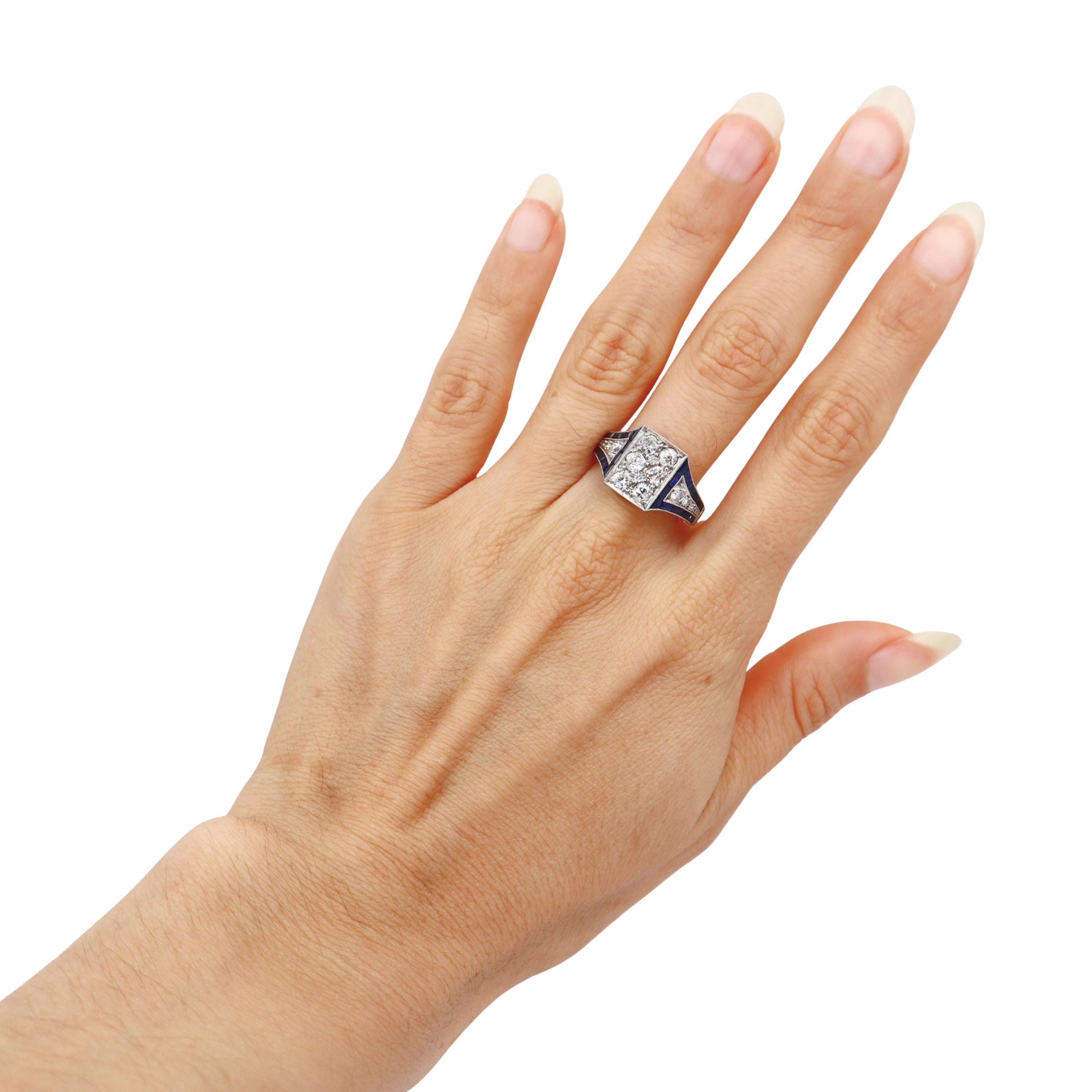 Este asombroso anillo Art Déco ejemplifica la sofisticación geométrica de los años 20, elaborado en brillante platino y con 14 diamantes de mina antigua que suman 1,25 quilates de color brillante H y claridad VS-SI1, bellamente contrastados por 0,70