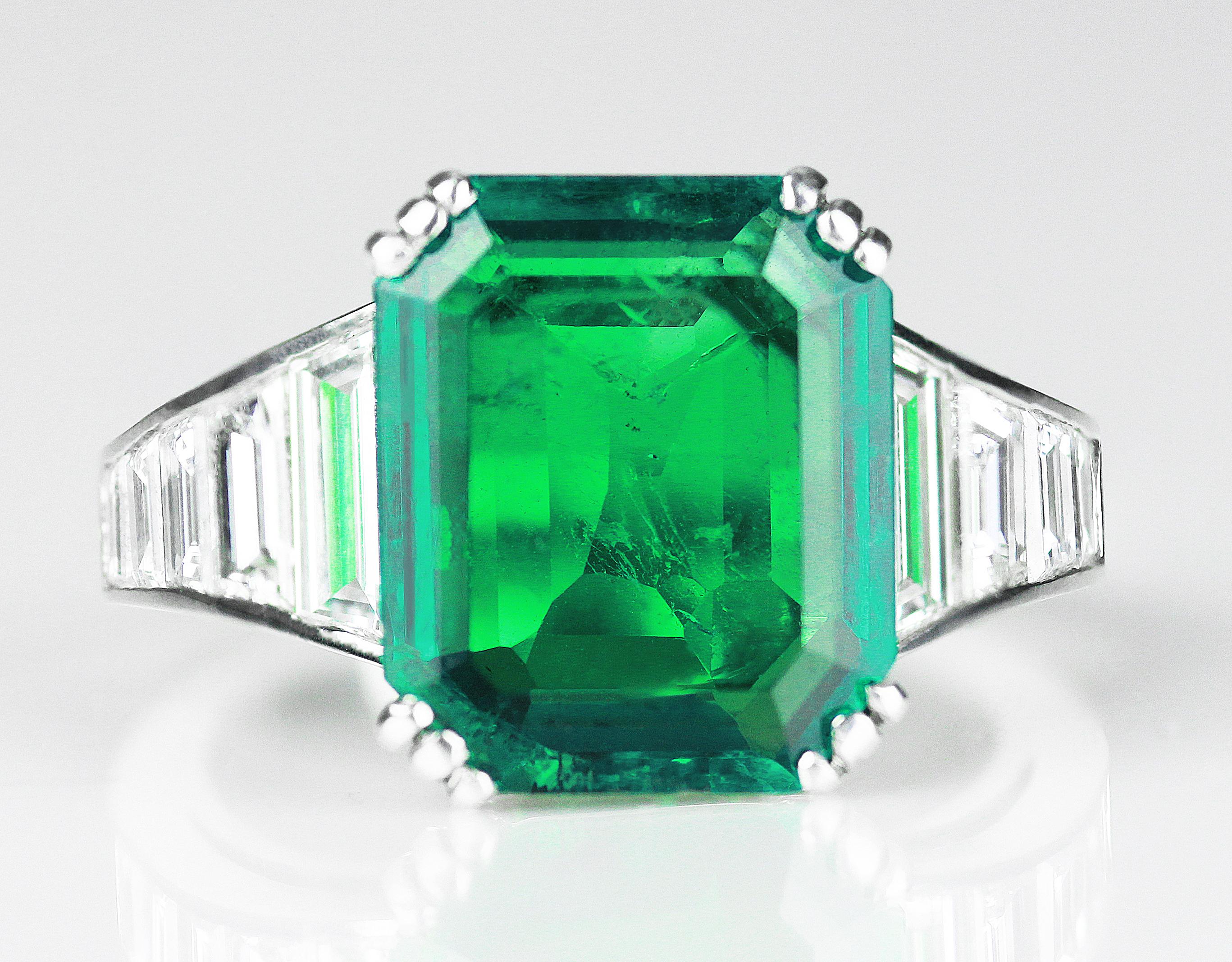 This stunning piece is a 4.09 ct  emerald & diamond in platinum ring formatting of a hexagon emerald, a deep royal green shade placed on a classic band with glistening baguette cut diamonds of graduating to the sides. The mysterious depth of the