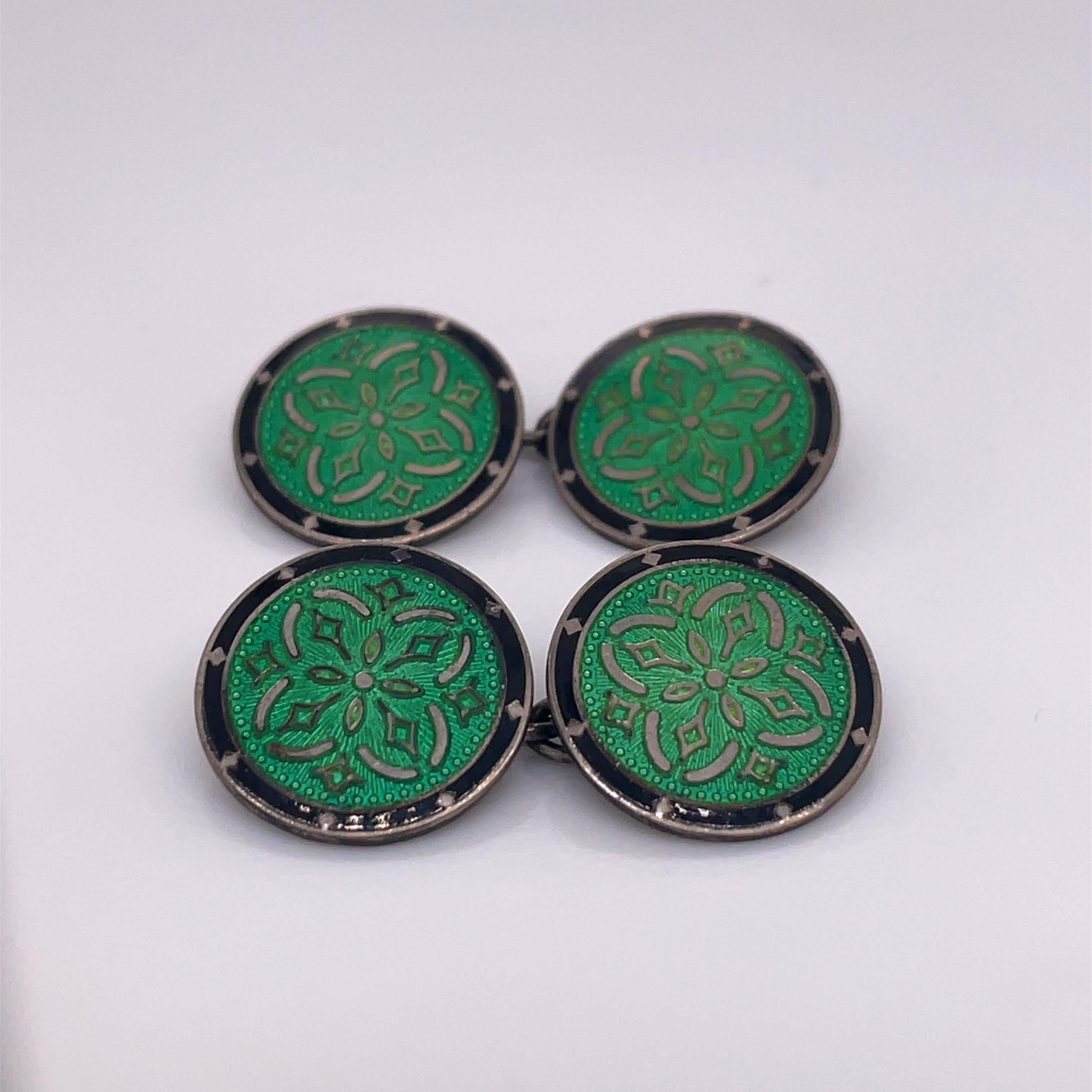 This is a spectacular pair of 1920s Art Deco enameled cufflinks perfect for any man who likes to accessorize! These cufflinks are in sterling silver and enamel, featuring a daring glowing green and a dark black enamel frame. These links are
