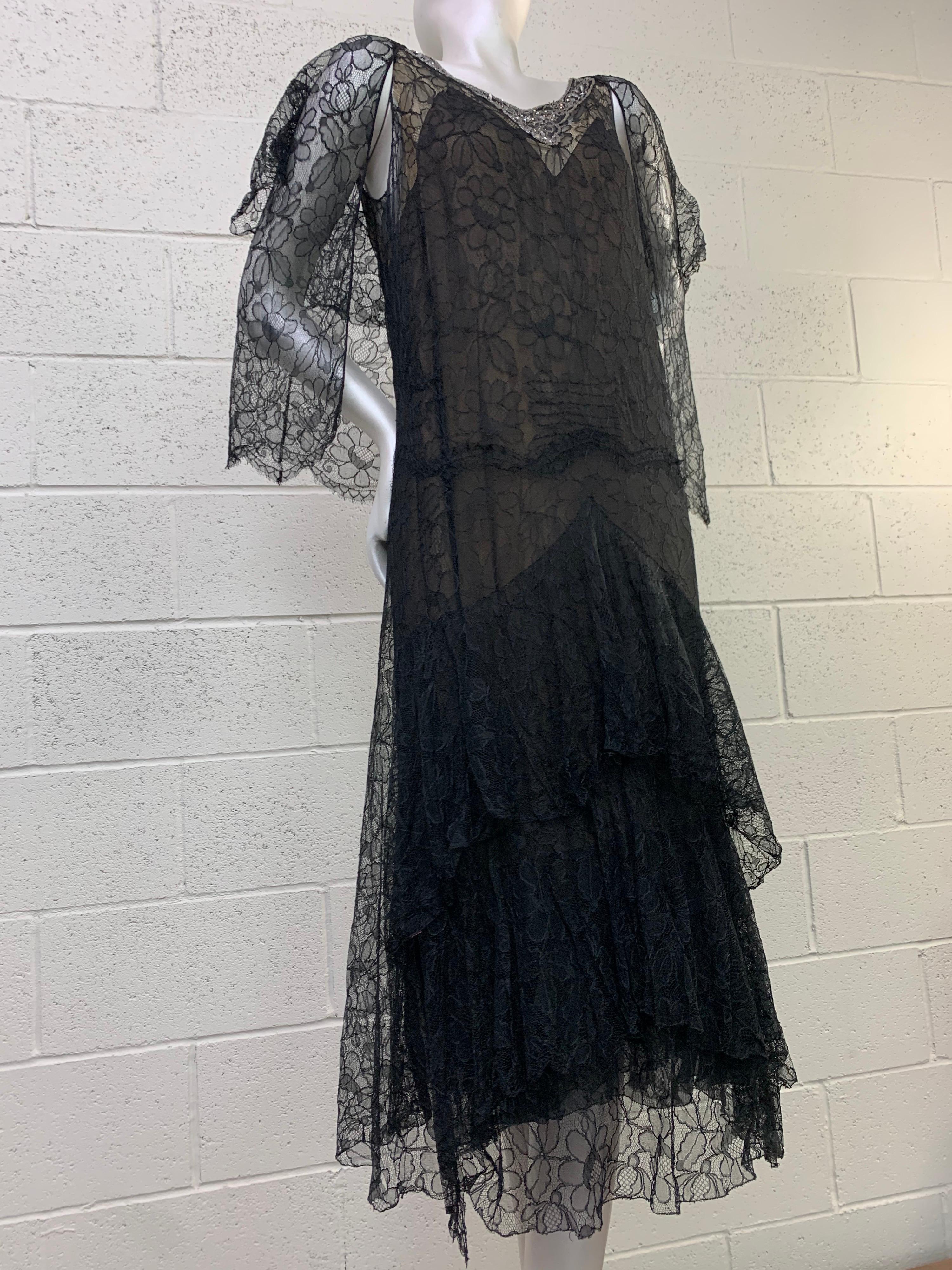 An exquisite 1920s Blackshire black silk lace dress with tiers of ruffle detailing in skirt and a matching jacket. Neckline and low scoop back are embellished with faux pearls and beadwork. Such an enchanting ensemble. Size 4-6.