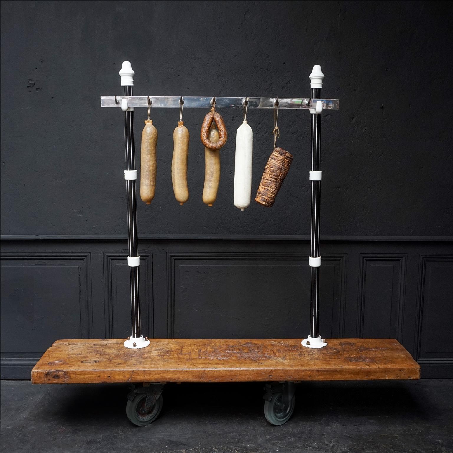 Heavy early 20th century Art-Deco window display butcher meat rack set, from a 1920s-1930s Butcher shop. Set of two black and white enamelled cast iron poles, with a heavy metal meat rack with 7 very sharp hooks. The poles can be mounted with the