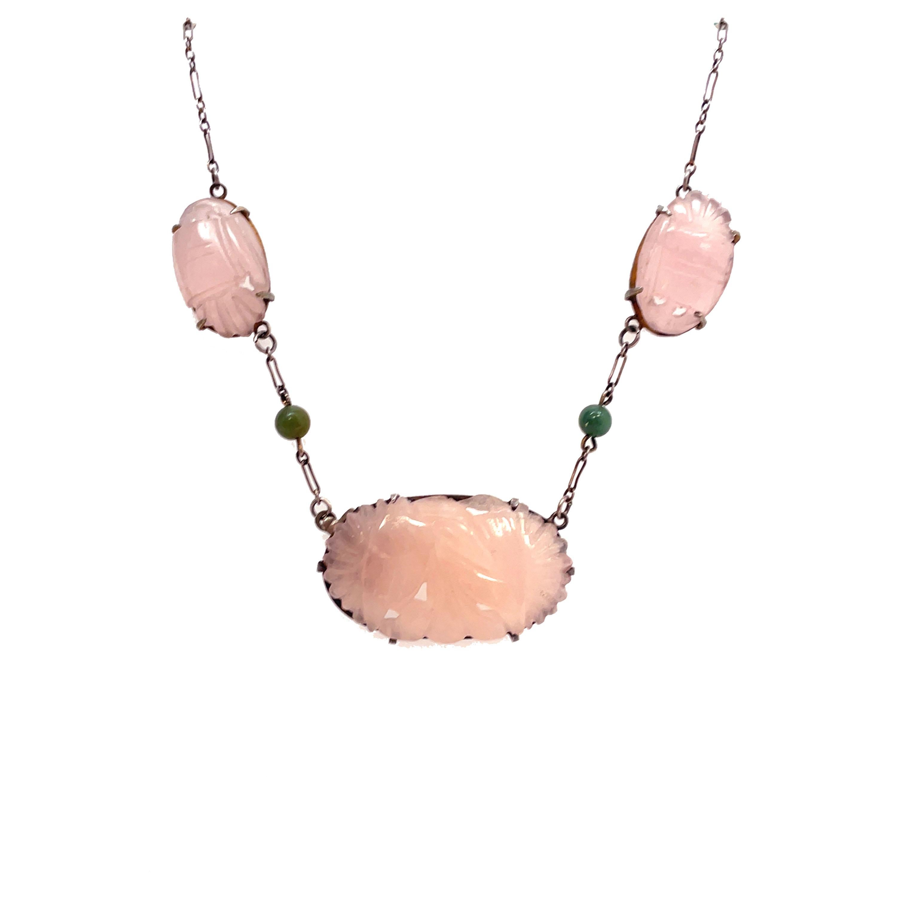 This is an enchanting sterling silver necklace from the Art Deco period that features beautiful hand-carved rose quartz and dazzling jade beads. The lovely shade of dusty pink compliments the lush green jade beads cascading down the neck. This