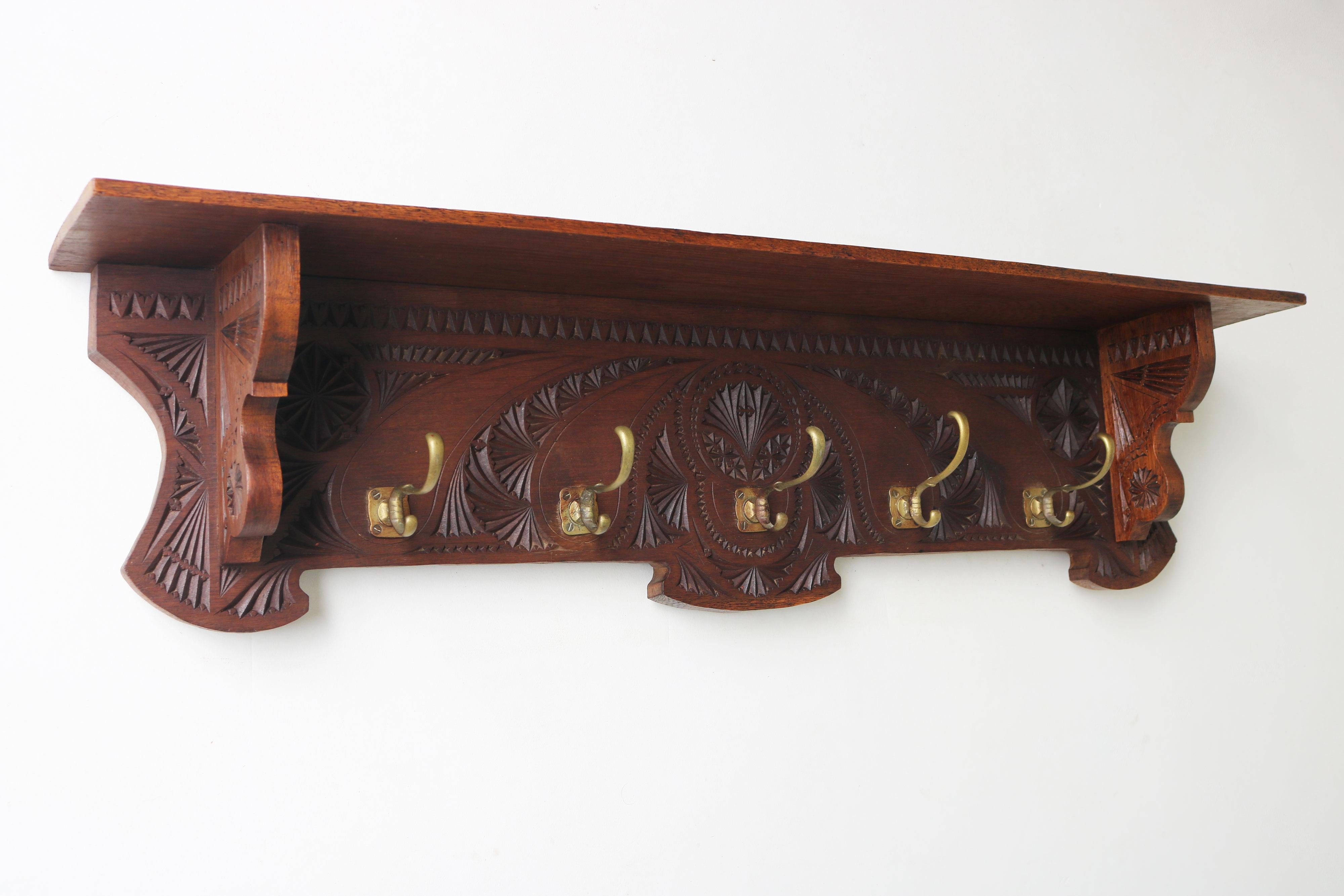 Encantador perchero holandés de Artes y Oficios, tallado en virutas de Arte Popular, con preciosos ganchos de latón originales de los años 20  
Ricamente decorada y totalmente tallada a mano por todos sus lados con una artesanía exquisita.  
Los