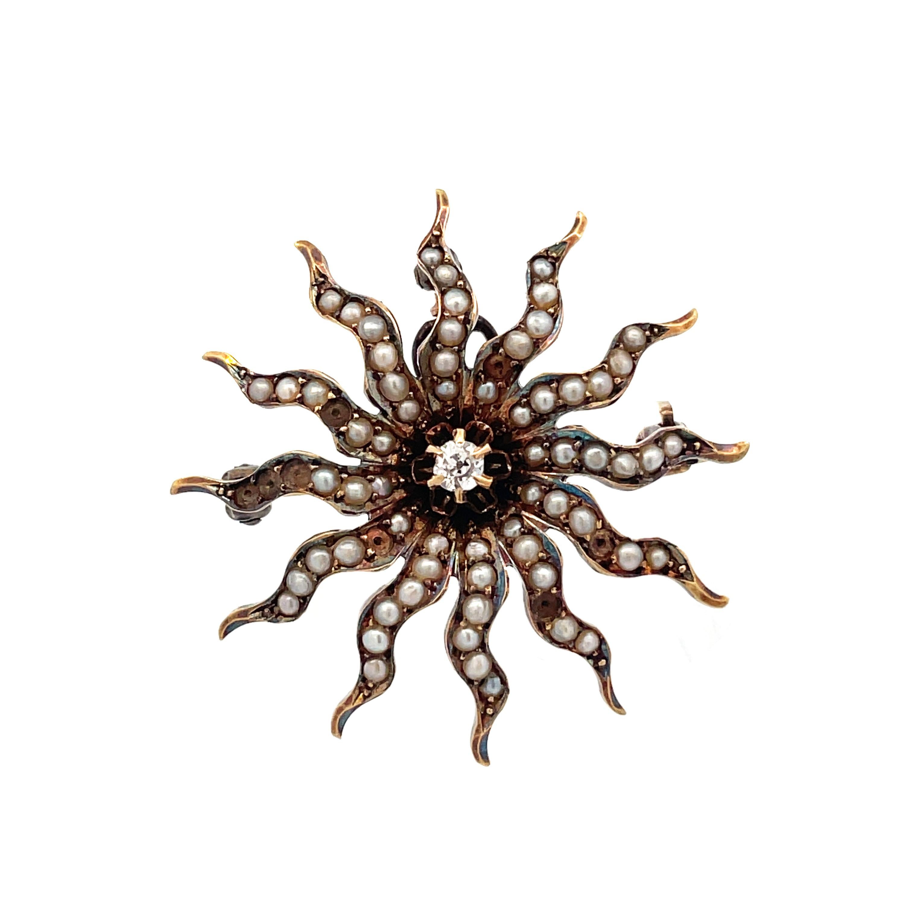 This is a beautiful Edwardian pin/pendant crafted in 14K yellow gold that showcases a stunning collection of seed pearls and an Old Mine Cut diamond at the center. This lovely Edwardian pin has a whimsical sunburst design. The sun's rays are dotted