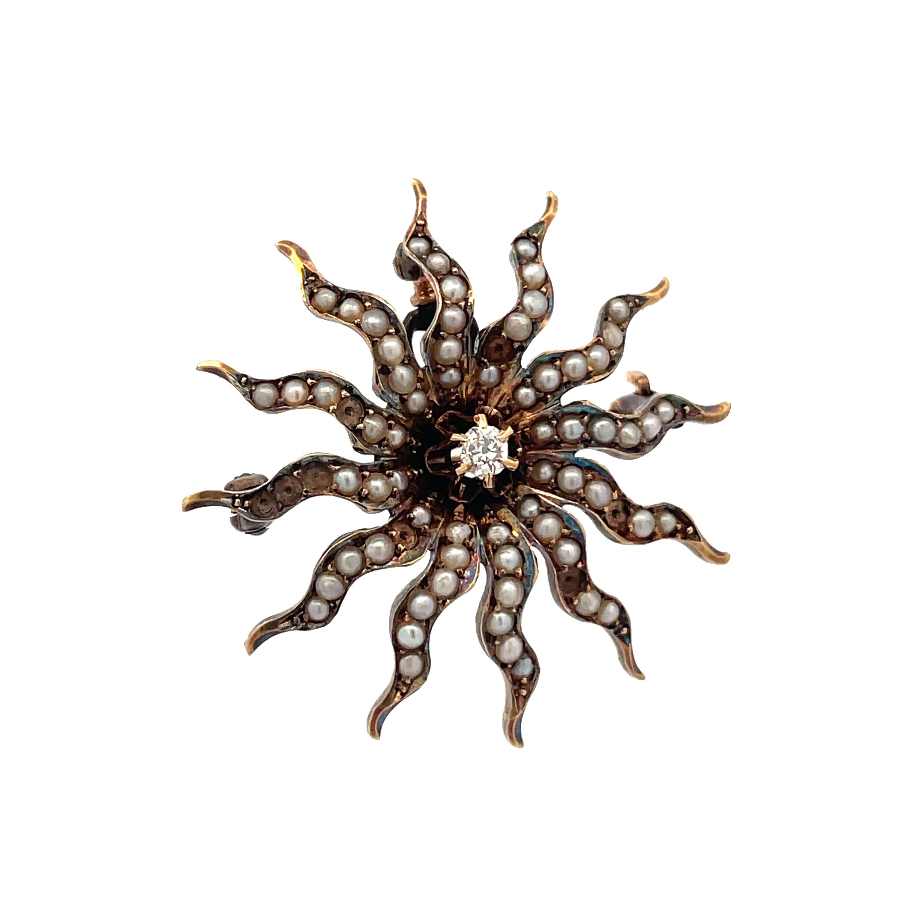 This is a beautiful Edwardian pin/pendant crafted in 14K yellow gold that showcases a stunning collection of seed pearls and an Old Mine Cut diamond at the center. This lovely Edwardian pin has a whimsical sunburst design. The sun's rays are dotted